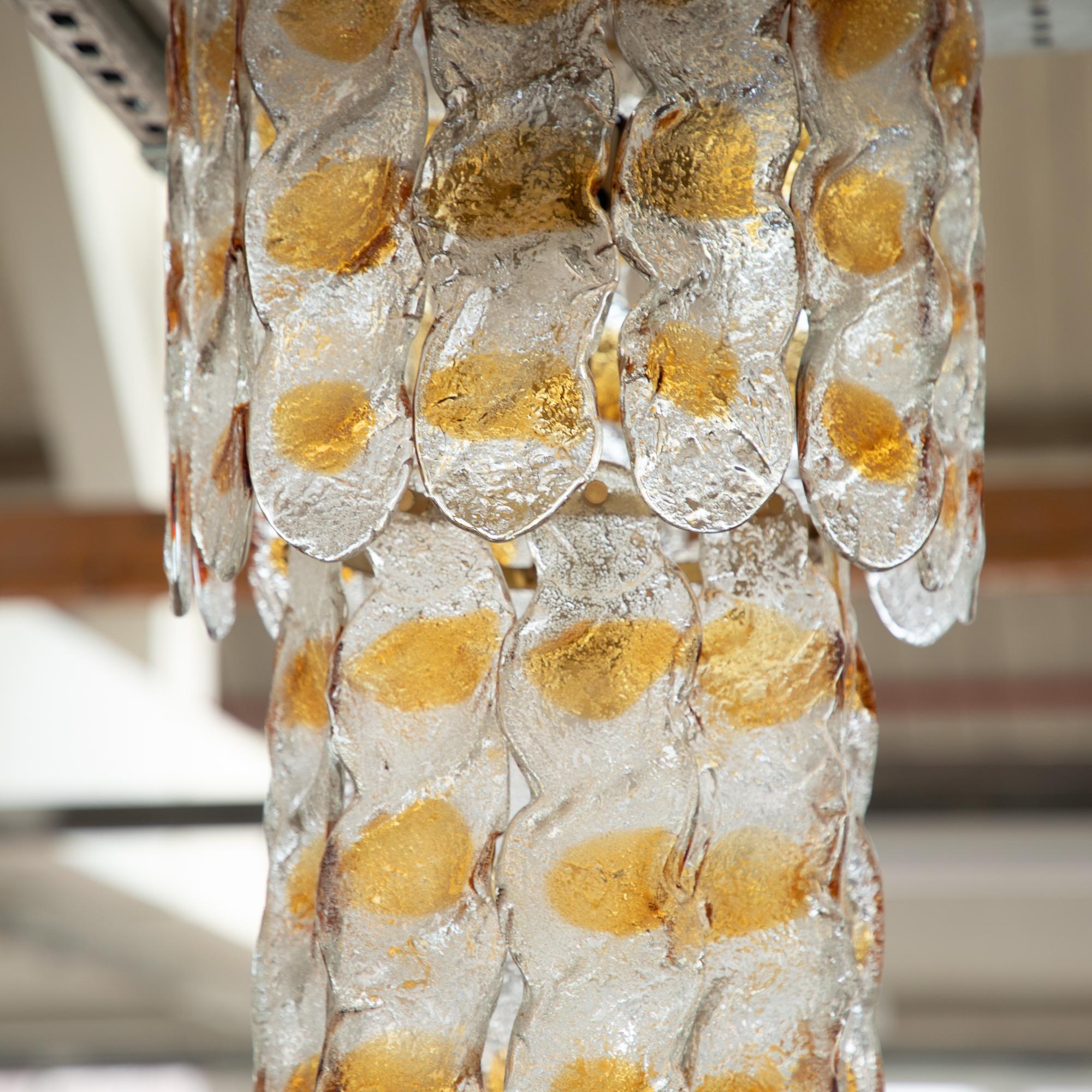 Vintage 1970s Murano glass chandelier, amber and transparent glass plates. The soft curvaceous plates have an opaque textured finish with amber glass details where the plates dip and undulate. The overall effect once hung is a soft and mesmerising