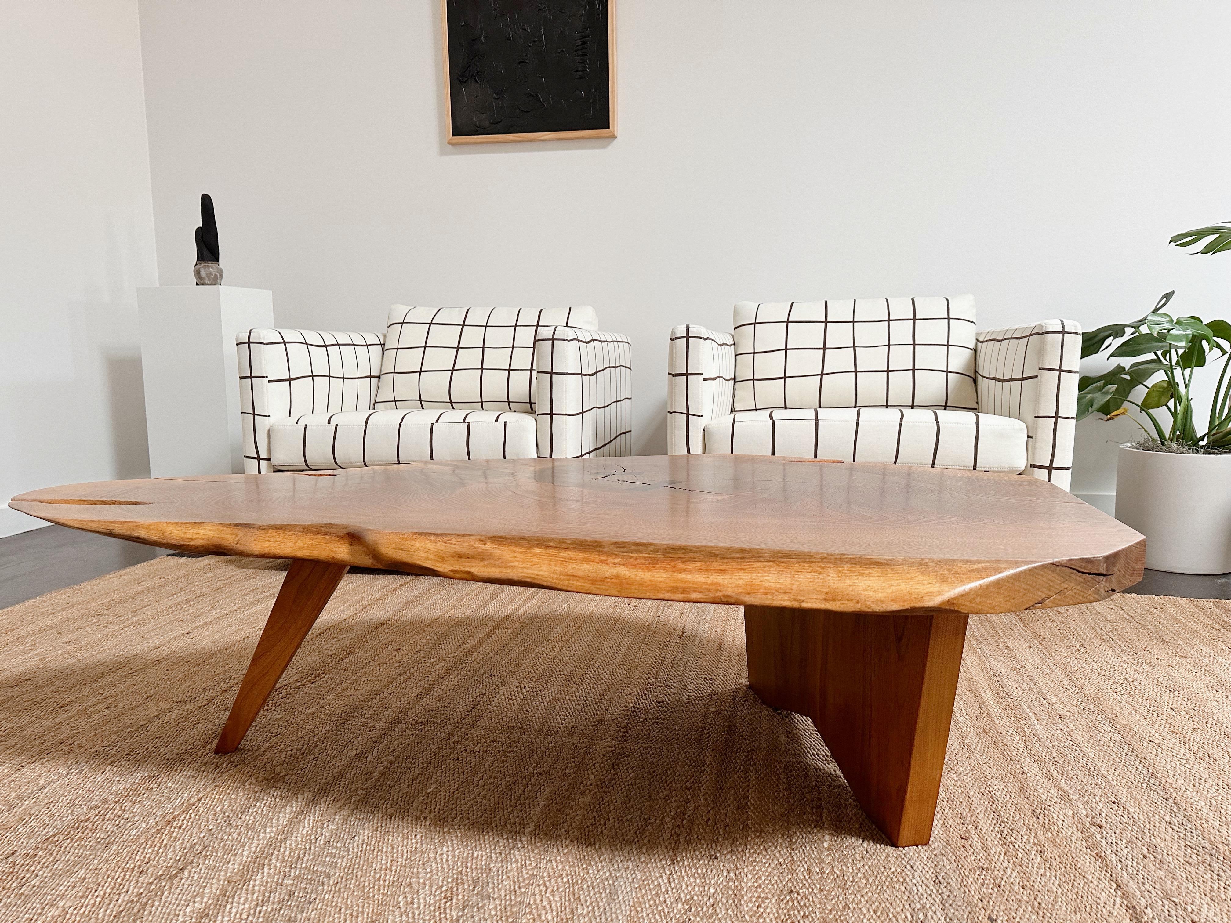 Une table basse américaine à une seule dalle avec de grands détails de nœuds, un grain expressif, des bords libres et coupés et un papillon en noyer.