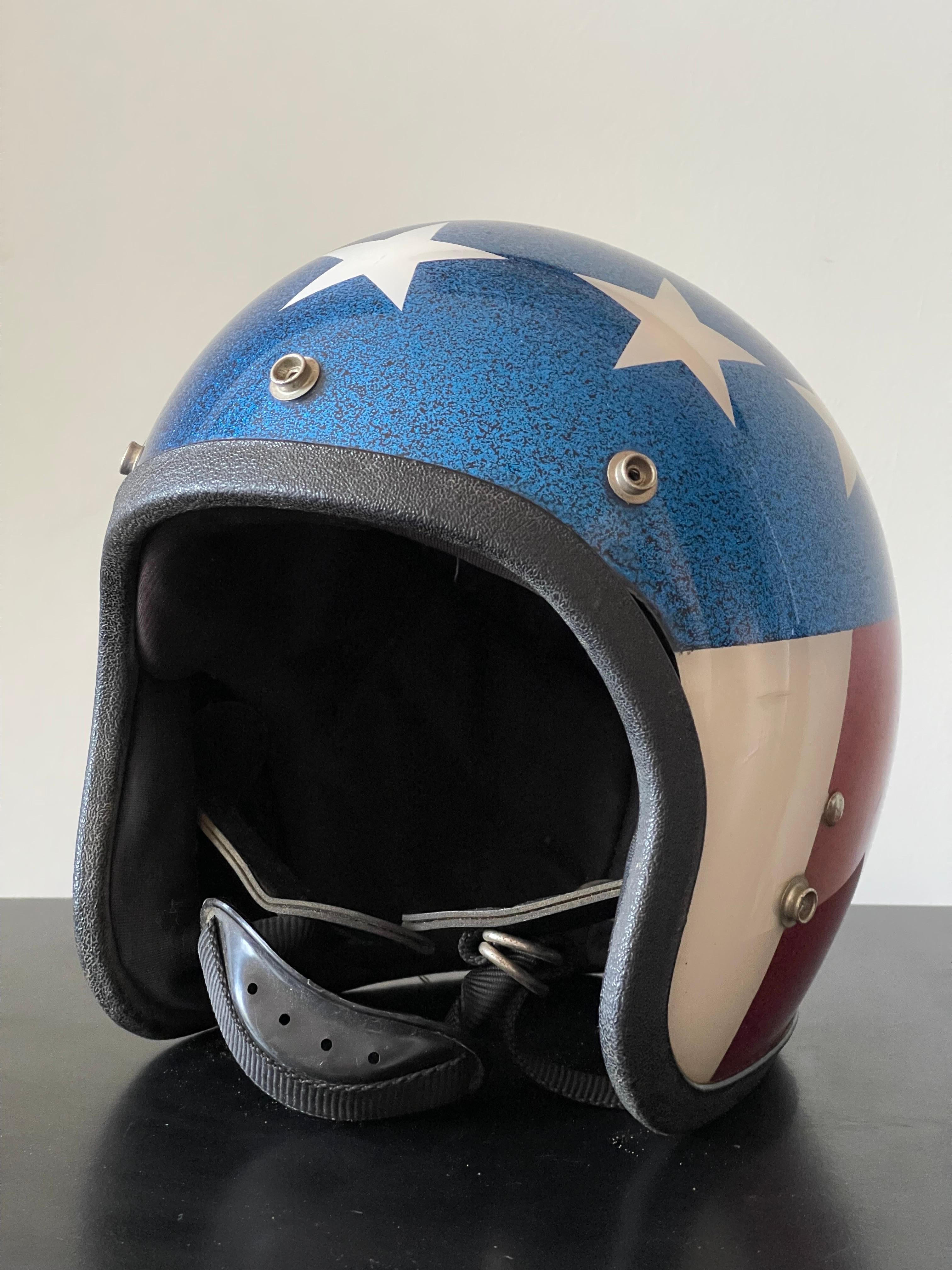 Very cool American Flag motorcycle helmet appears to have never been used. Original sticker still inside the helmet. Rare chinstrap with it, as they usually comer off. Very nice shelf decor. 
The inside foam is disintegrating (sign of never being