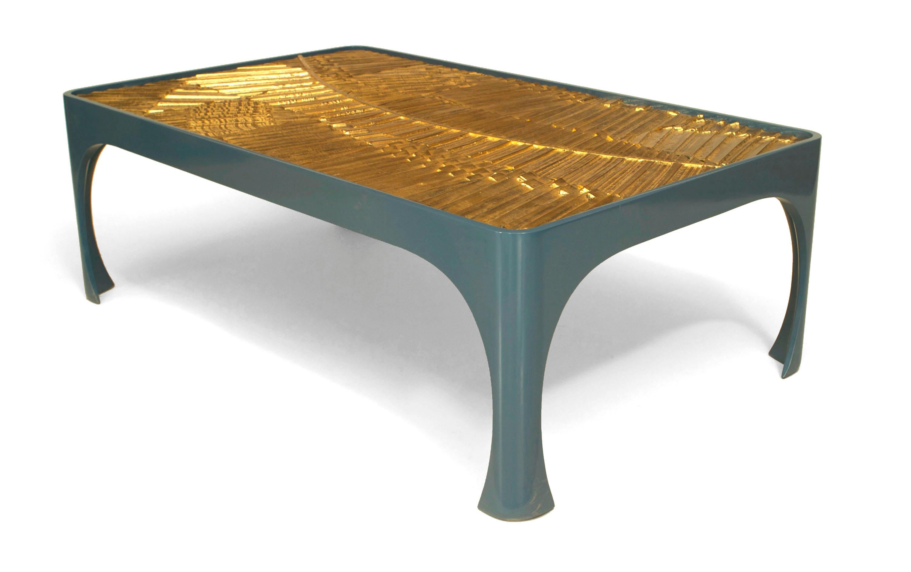 American rectangular coffee table comprising an inset 1970s gilt resin geometric sunburst design panel set in a modern blue lacquered base.