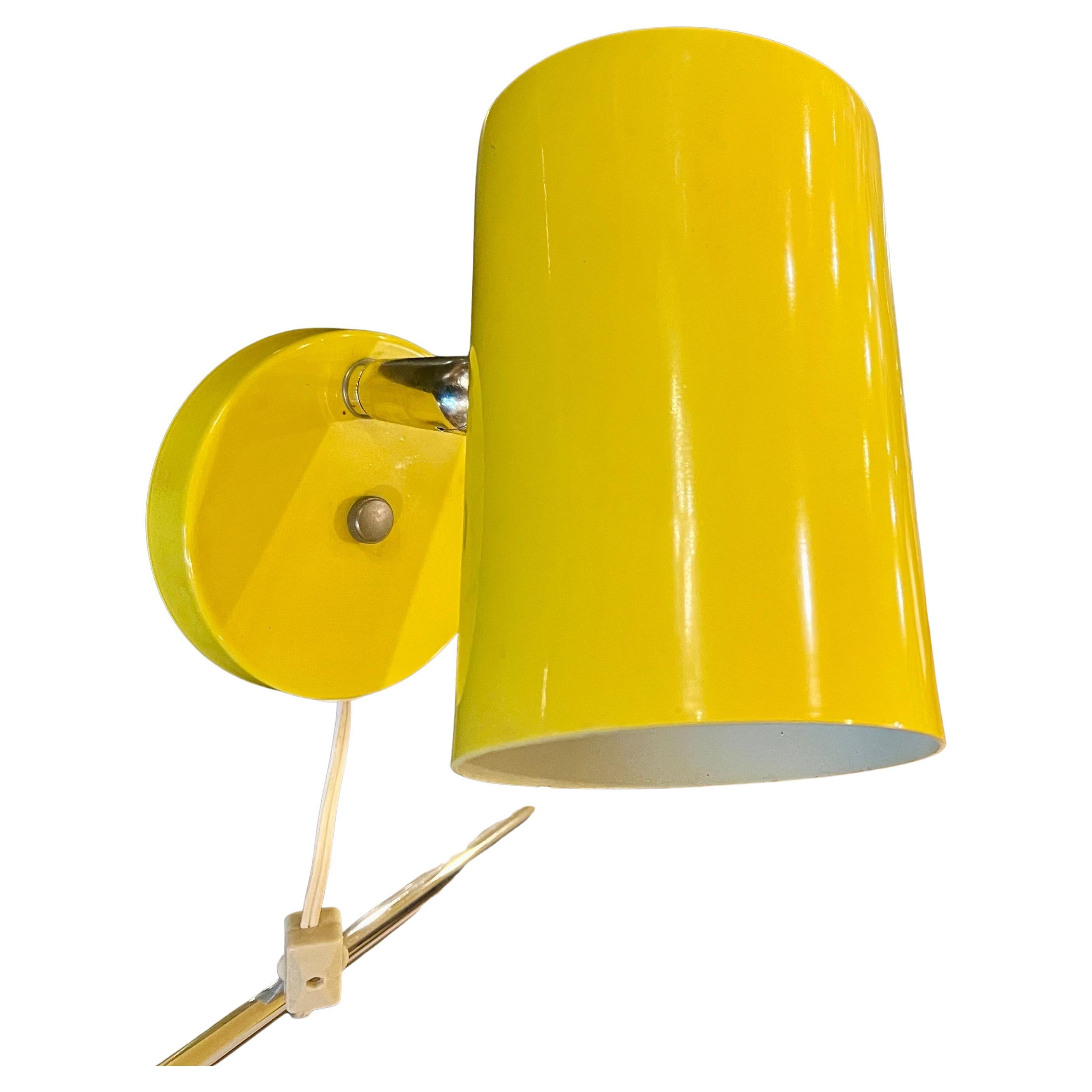 Lampada multidirezionale da parete degli anni '70 in ottime condizioni, può essere collegata a un cavo o a una presa di corrente, con una bella finitura smaltata gialla, il paralume può essere appeso alla parete e si muove verso l'alto e verso il