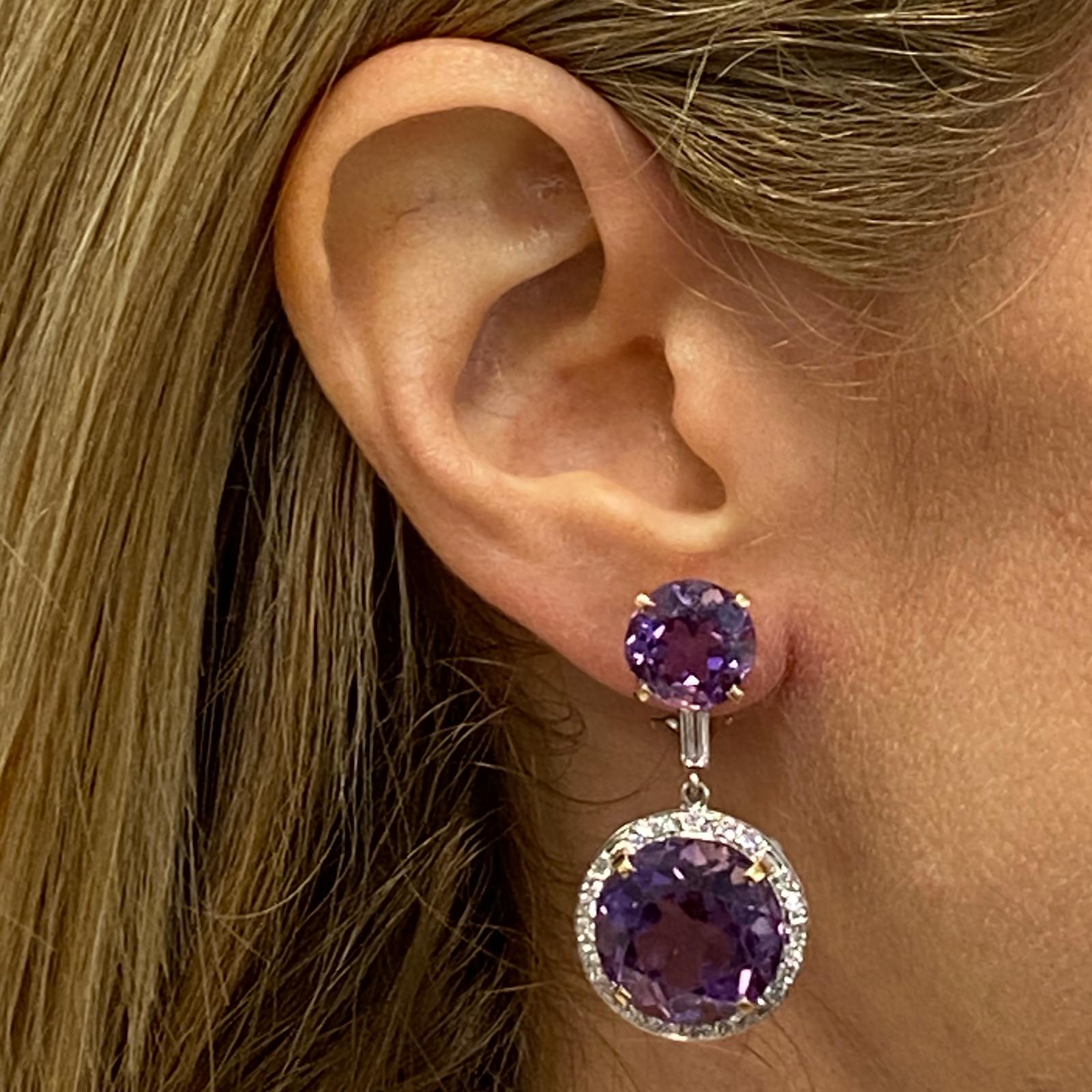 Beautifully crafted diamond and amethyst drop earrings fashioned in 14 karat white and yellow gold. The earrings feature 4 round amethyst gemstones weighing approximately 36.30 carat total weight. The bright purple gemstones are accented with