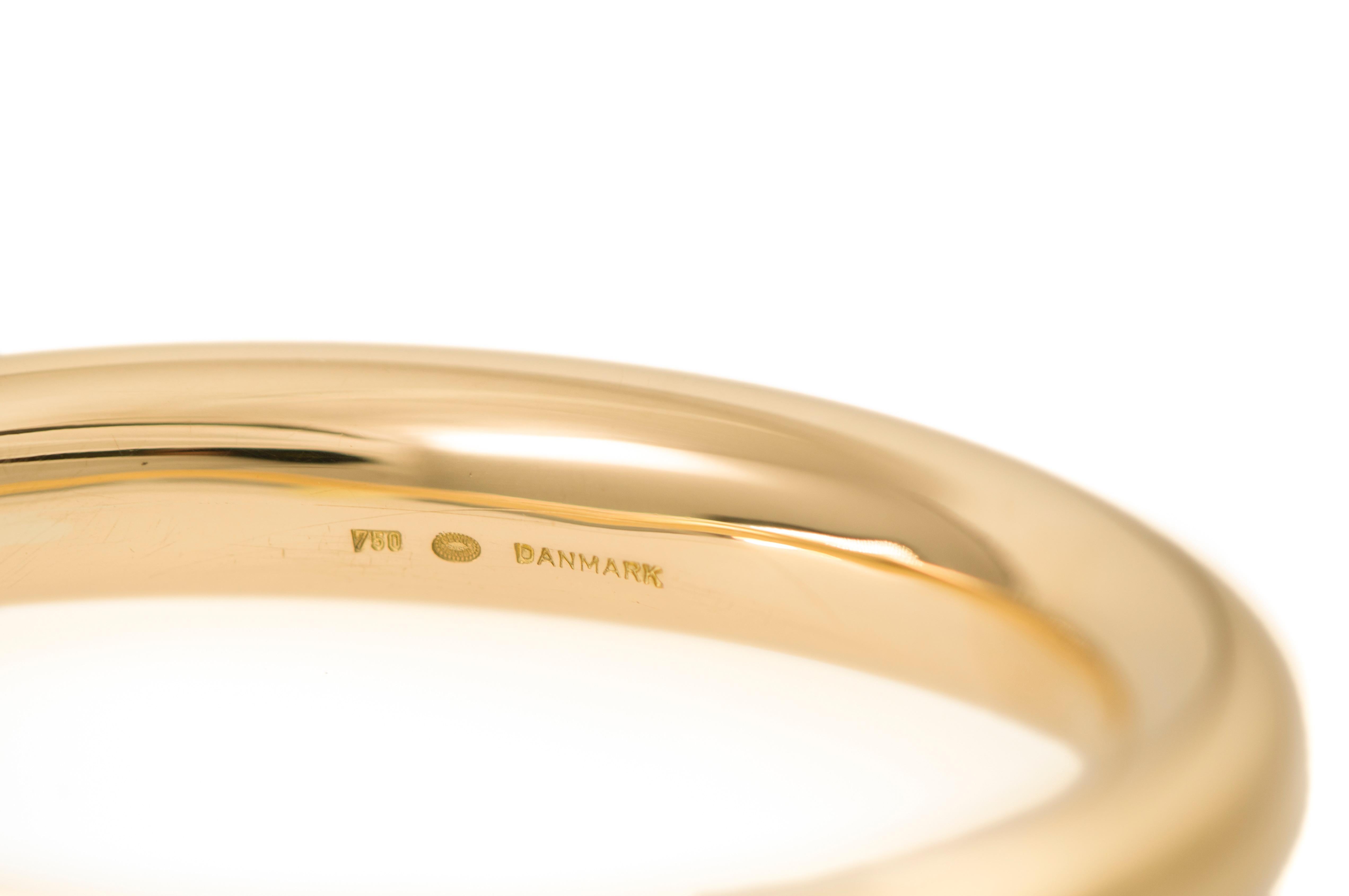 An 18 karat gold bangle bracelet, by Anne Ammitzbøll for Georg Jensen, c. 1975

The bracelet is stamped 750 and Denmark, with makers mark for Jensen and Ammitzboll. It has an interior circumference of 8
