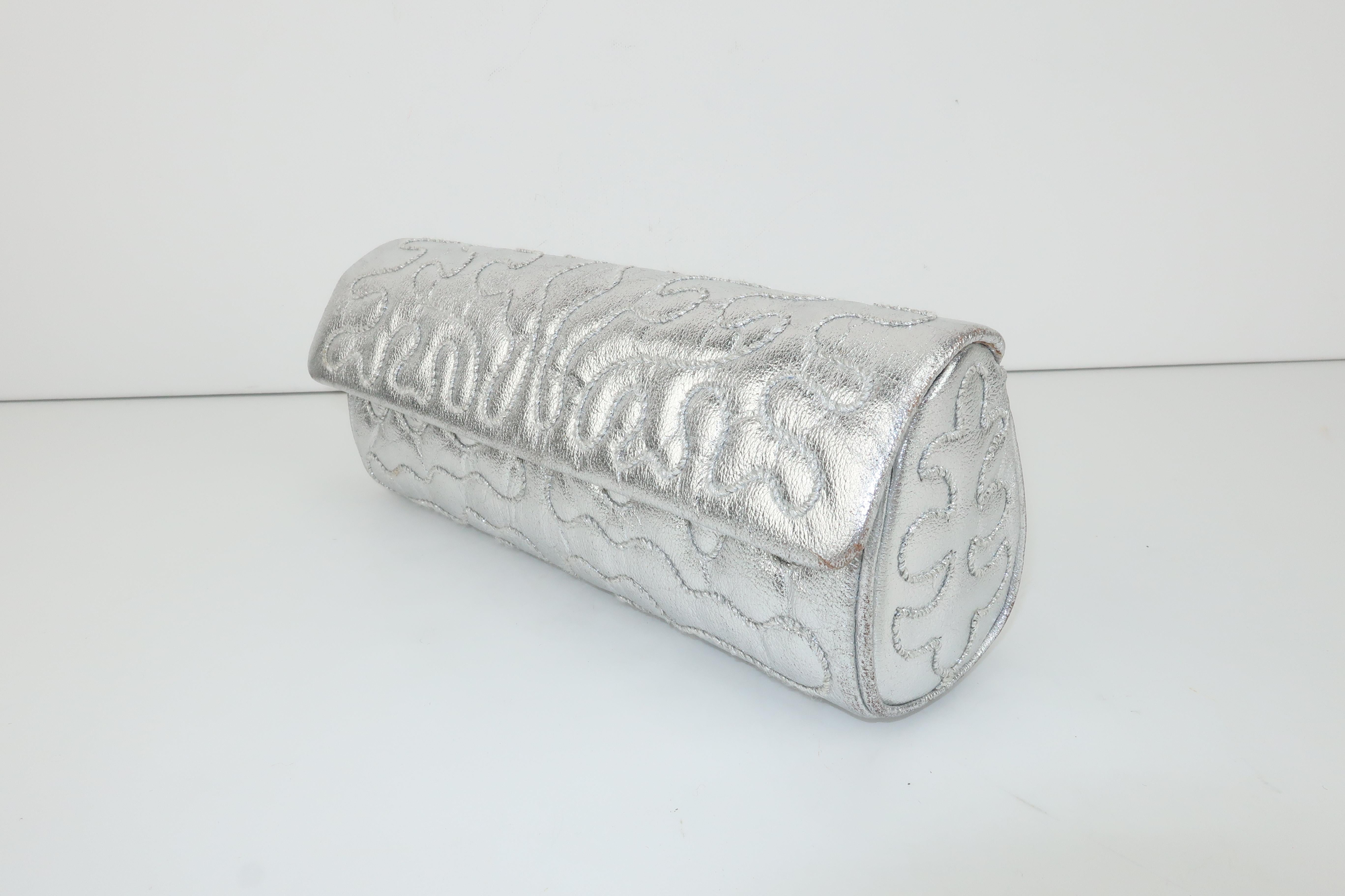 Be a disco diva with this stylish silver leather clutch handbag designed by Anne Klein for Calderon in the early 1970's.  The passementerie style quilting is achieved with silver lamé threading stitched in scrolling patterns for visual interest. 