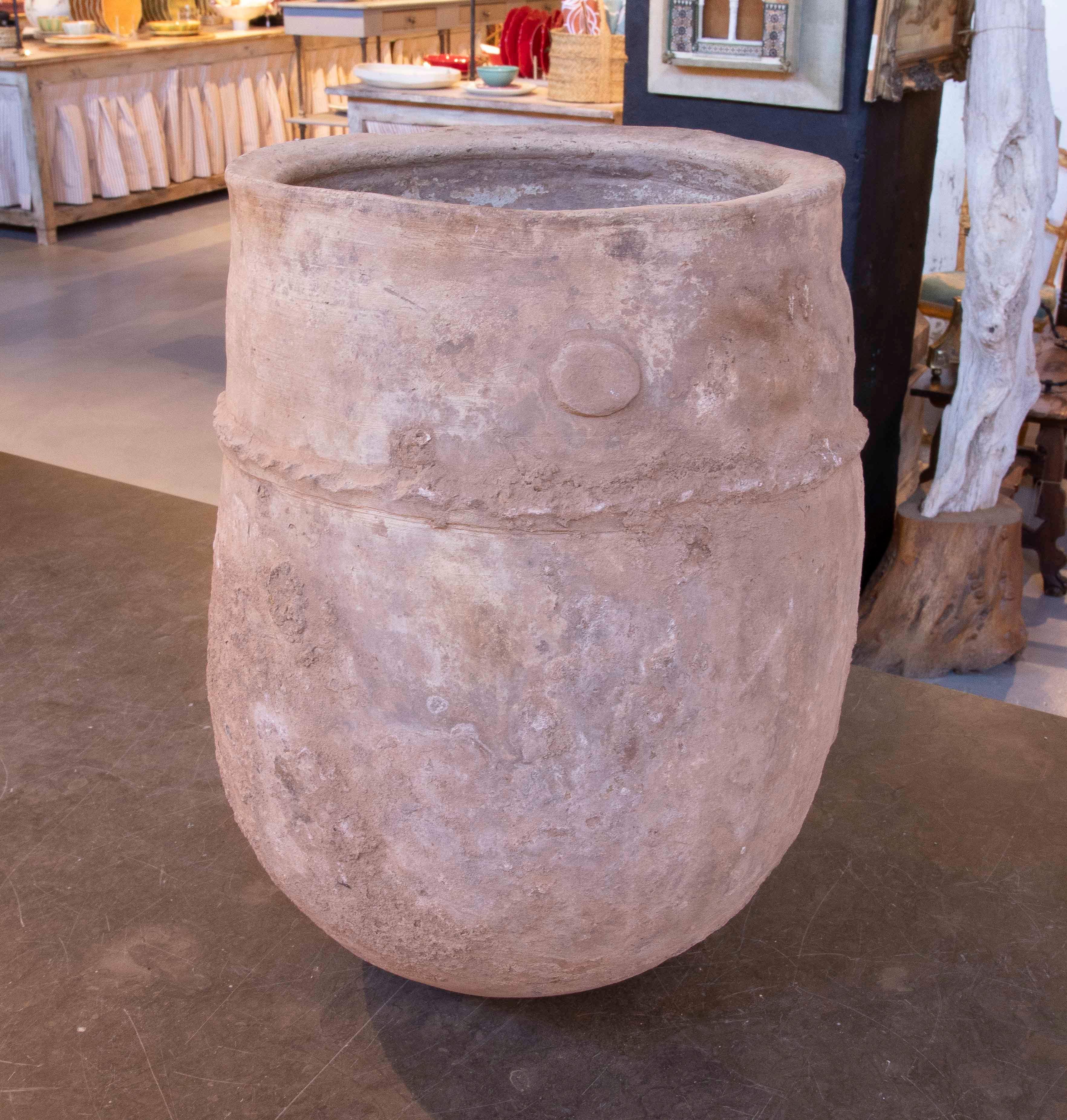 Une impressionnante jarre ancienne en faïence, fabriquée à la main avec une patine naturelle qui révèle son authenticité et le passage du temps. Sa surface texturée et ses tons terreux lui confèrent un charme rustique idéal pour l'intérieur ou