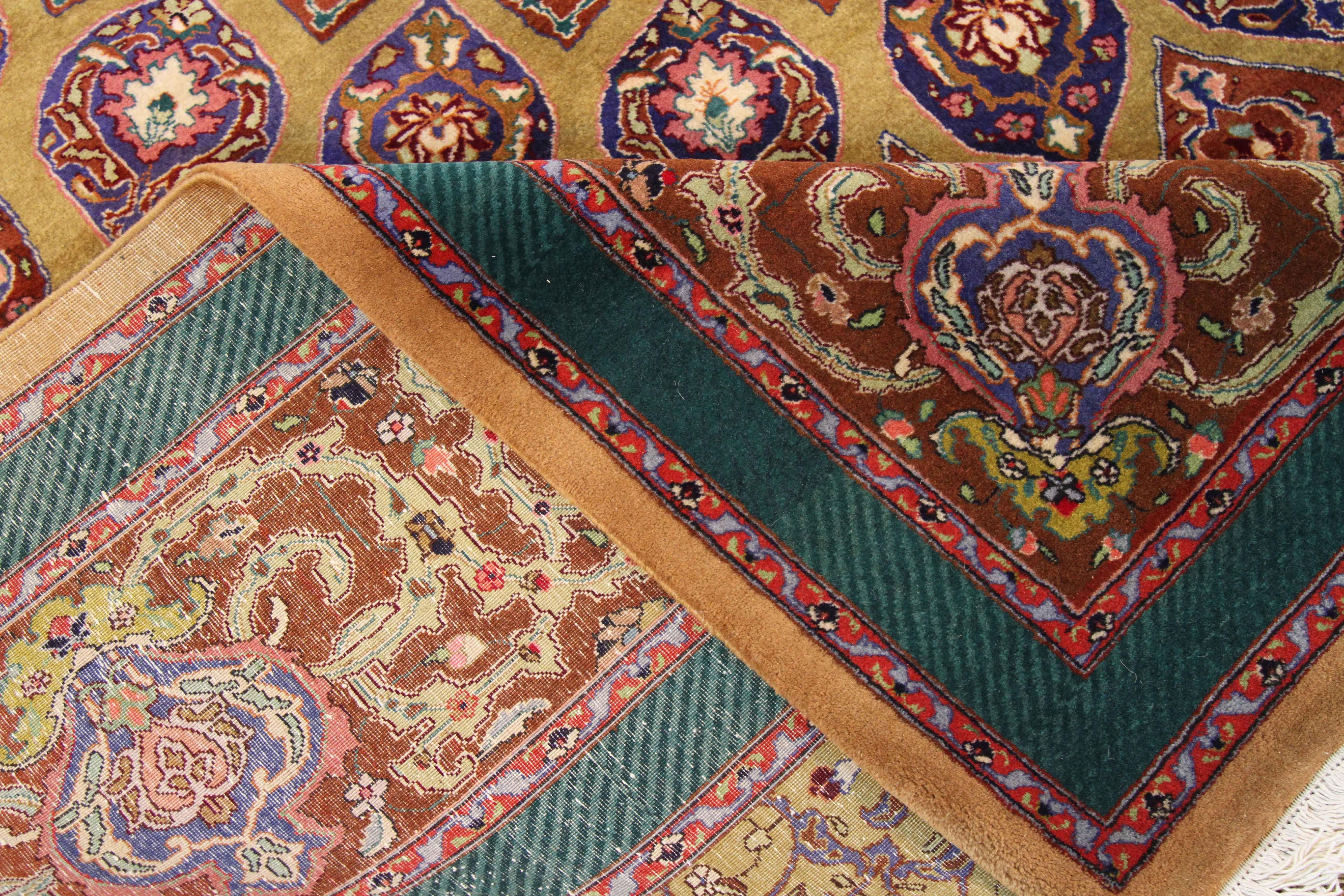 Antique Persian rug handwoven in the 1970s from fine wool and all-organic dyes. It presents repeating floral patterns arranged circularly on the center field. It has deep green, red, navy, and yellow color palette that gives off a semi-tribal appeal