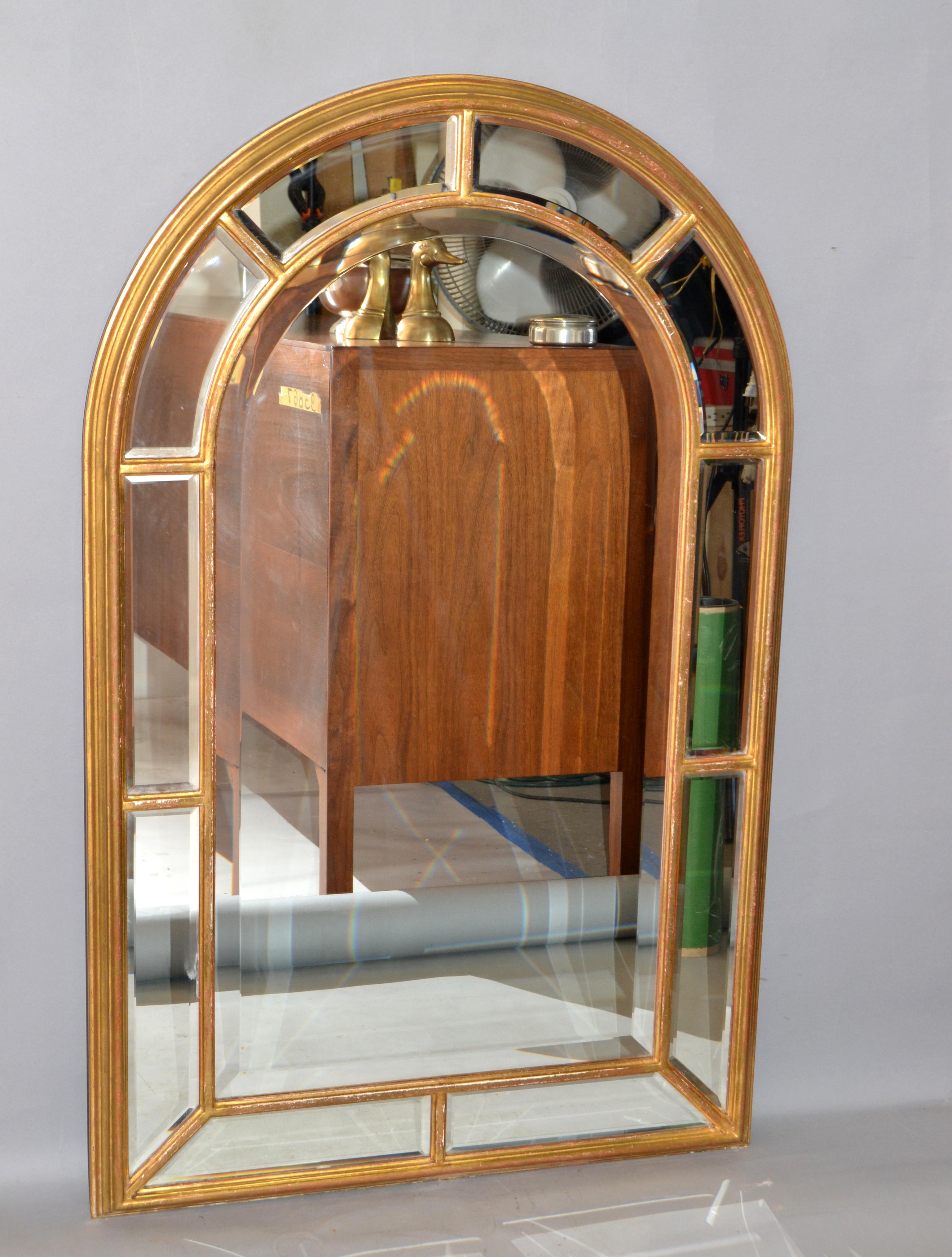 Arch shaped vintage Giltwood and beveled glass mirror with geometric architectural motif, Italy, circa 1970. Multiple panels of beveled glass are trimmed out with simple bands Giltwood. The form resembles columns at the sides capped with an arch,