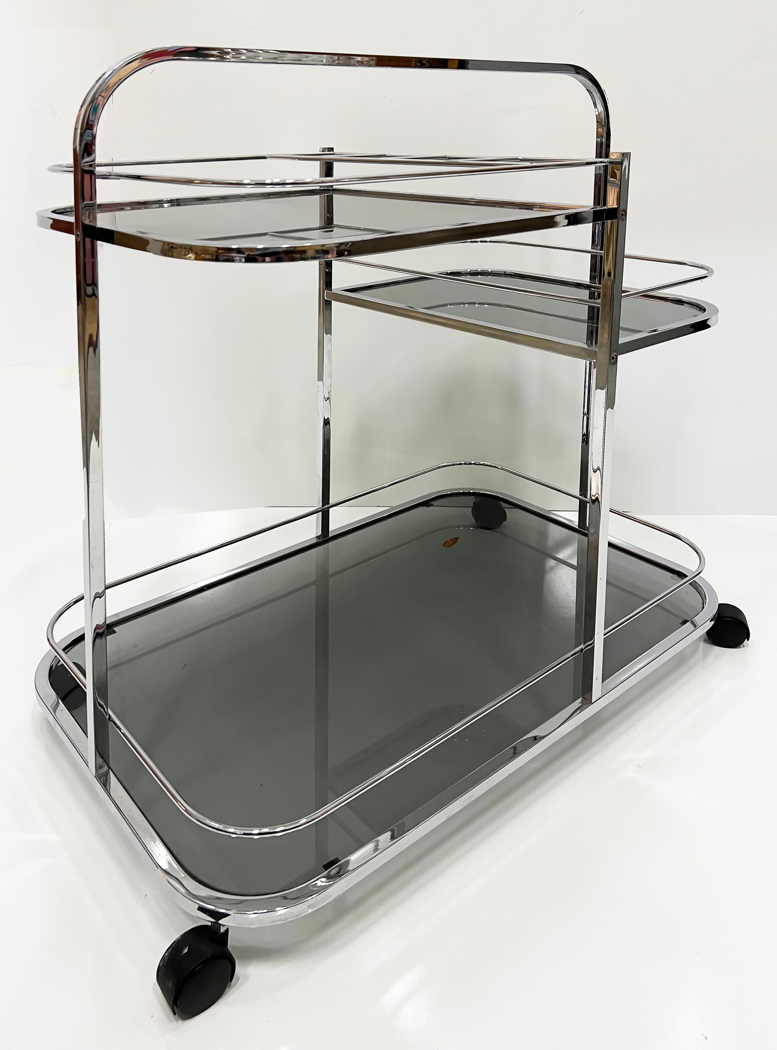 Gestufter Barwagen im Art-Déco-Revival-Stil aus Chrom, Rauchglas, 1970er Jahre

Zum Verkauf angeboten wird ein 1970er Art Deco Revival Barwagen in Chrom und Rauchglas Der Wagen hat eine über die Spitze gebogenen Griff, der von einer Seite zur