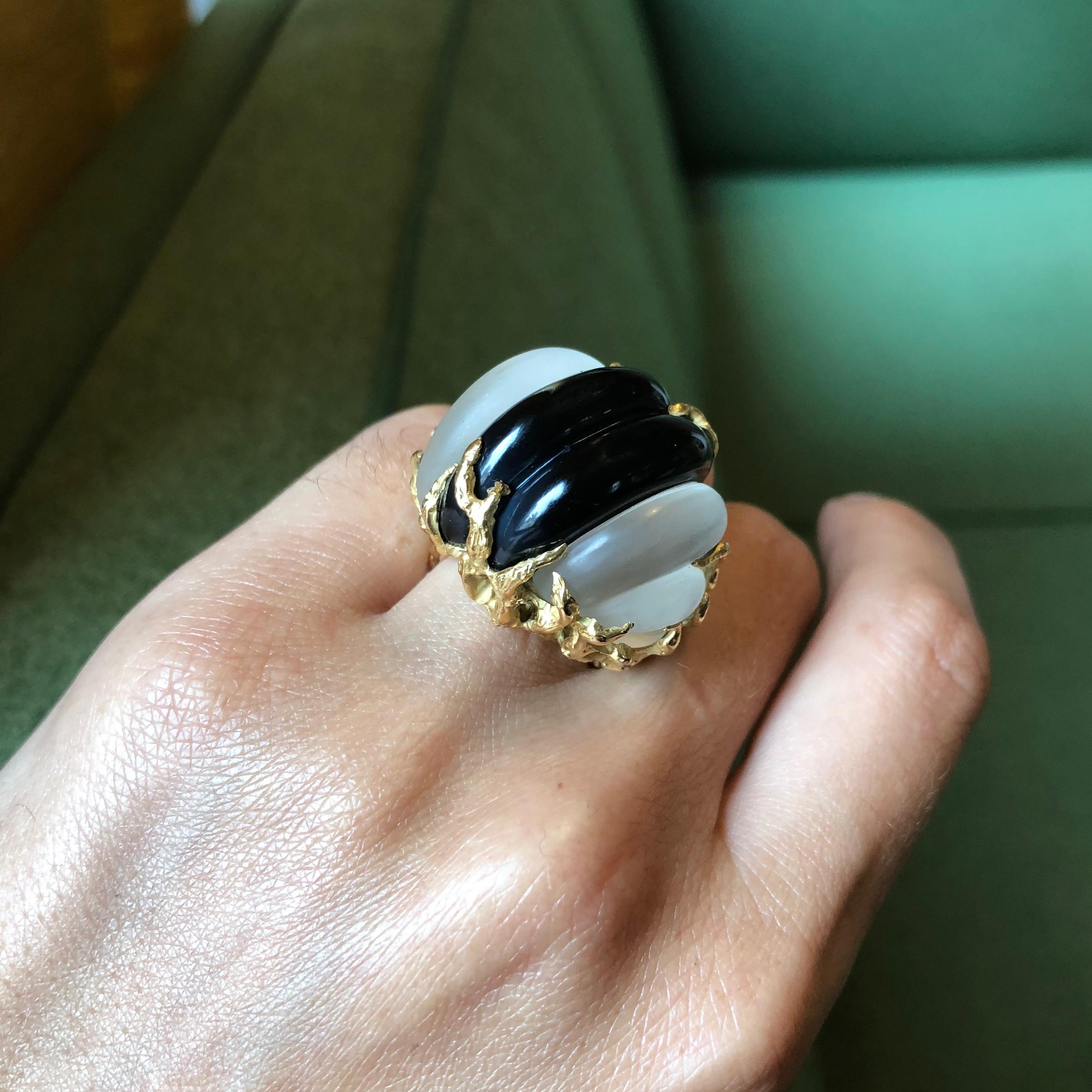 A carved rock crystal, onyx, and textured 18 karat gold ring, by Arthur King, c. 1970.

This ring measures size 5 and signed KING. Stamped 18k. 

Arthur King was based in New York City, where he opened a store in 1962, but also retailed in Miami,