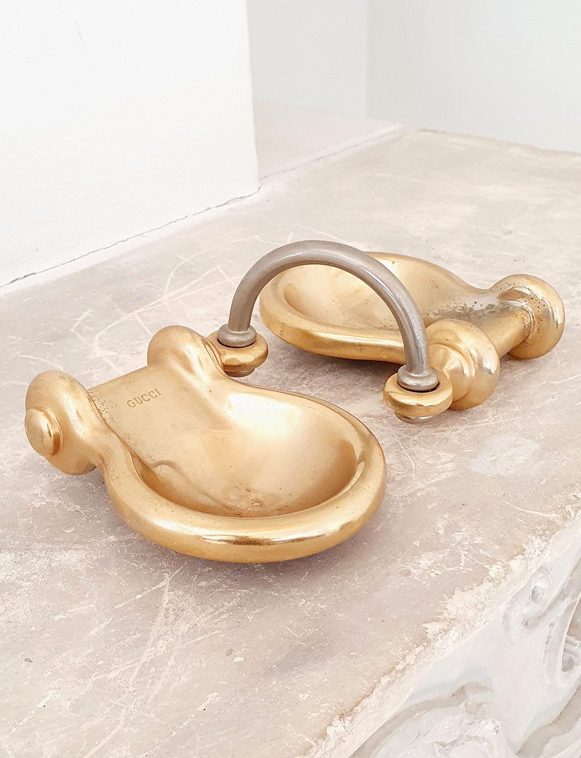This pair of conjoined heavy brass bowls or ashtrays were made by Gucci in Italy in the 1970s. They can be used either for aperitivo or on a desk or dressing table to hold small objects. The pair is stamped Gucci on each brass bowl and joined with a