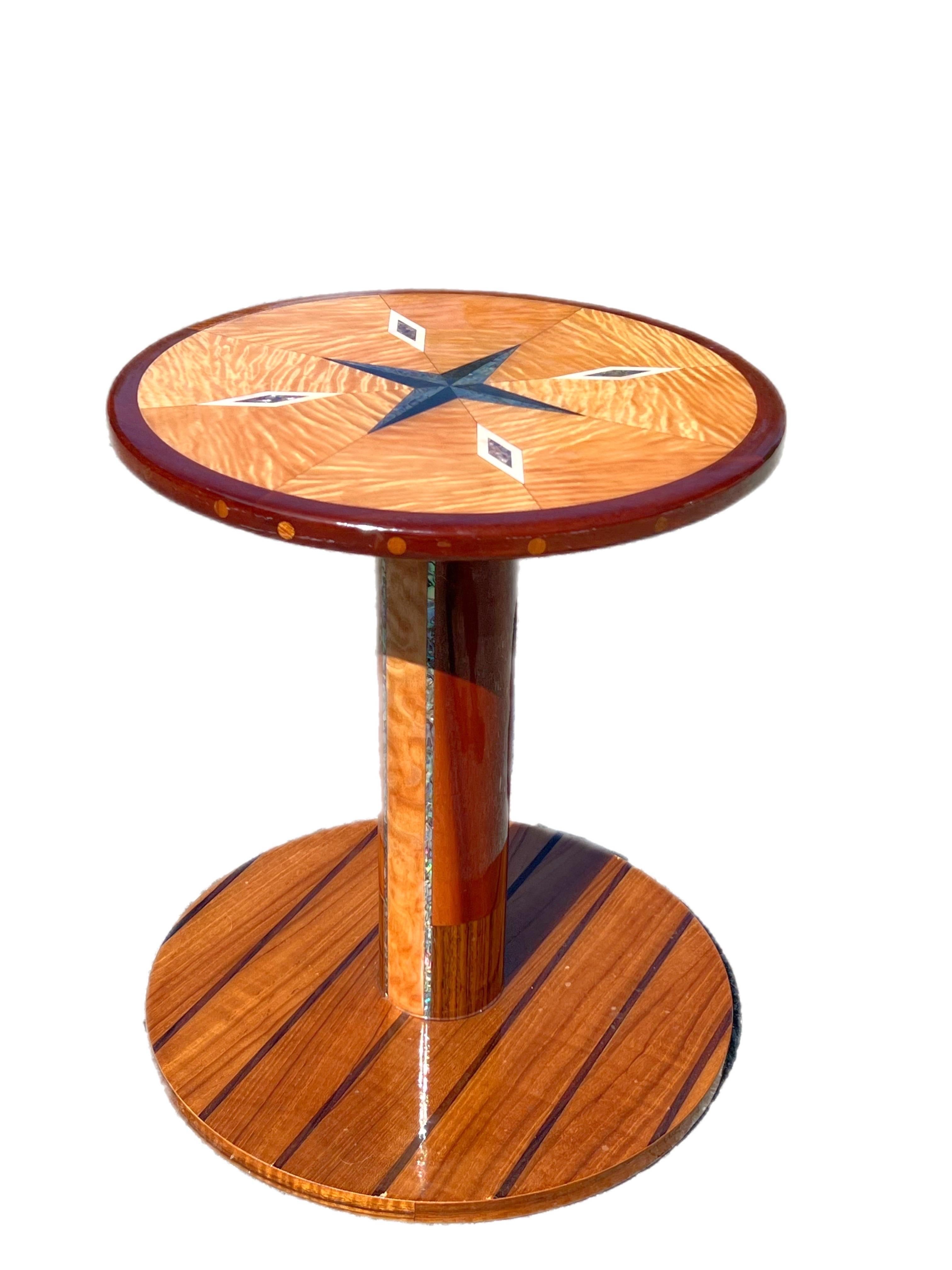 Artisan Crafted Specimen Compass Table
A stunning table inlaid with abalone shell, mother of pearl, and marble to form a compass rose on the table top.  Satin wood and teak, zebra wood and other exotic wood compromises the table.   The table has a