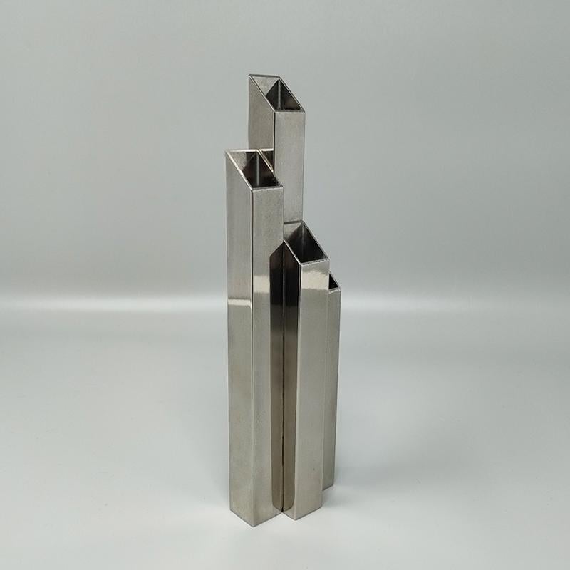 Vaso A Space Age degli anni '70 del Design M, con 4 parallelepipedi asimmetrici di diverse altezze in acciaio inossidabile. Made In Italy. Questo vaso è in ottime condizioni ed è firmato sul fondo.
Dimensioni:
2,36