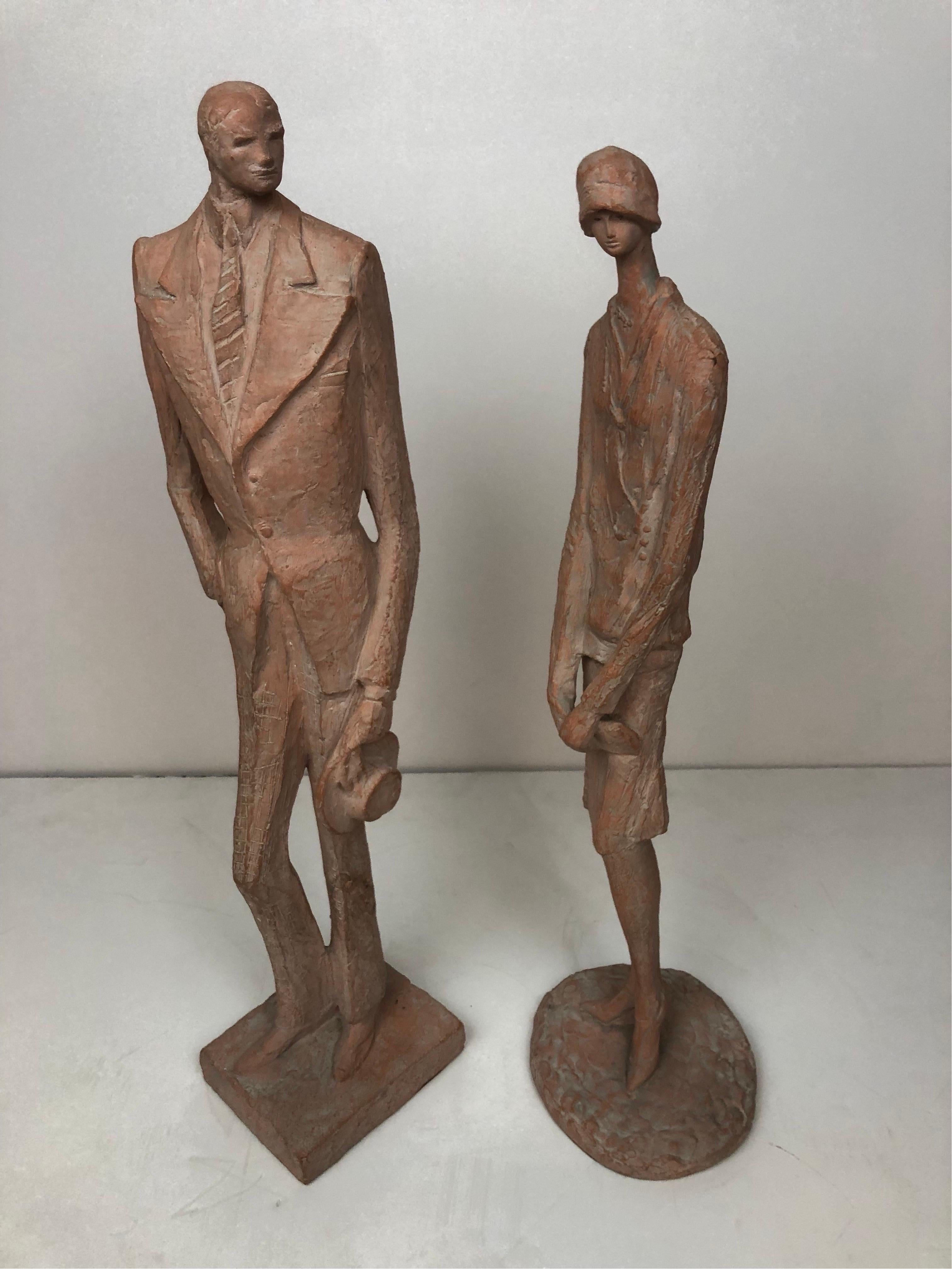 A cast resin couple dressed in stylized fashions of the mid 20th Century signed Austin Productions 1974 . 
Rarely found as a couple the female sculpture is often missing. The gentleman shows a sign of repair to the lower pants leg neither shows