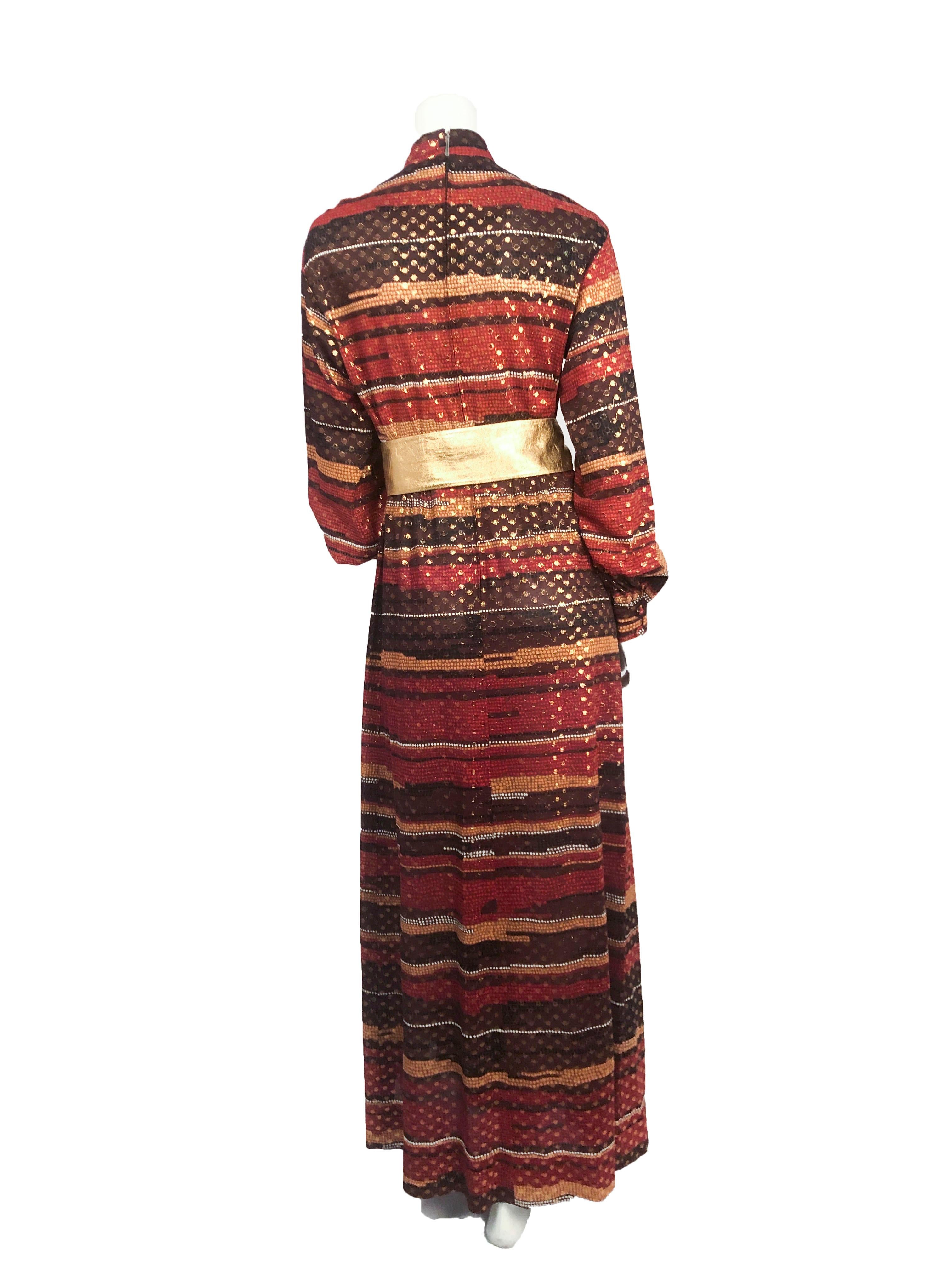 1970s Autumn Printed Full- length Dress with covered buttons, metallic Lurex textile, gathered/cuffed sleeves, nehru collar, and plackette collar accent. Styled with belt that is not included.
