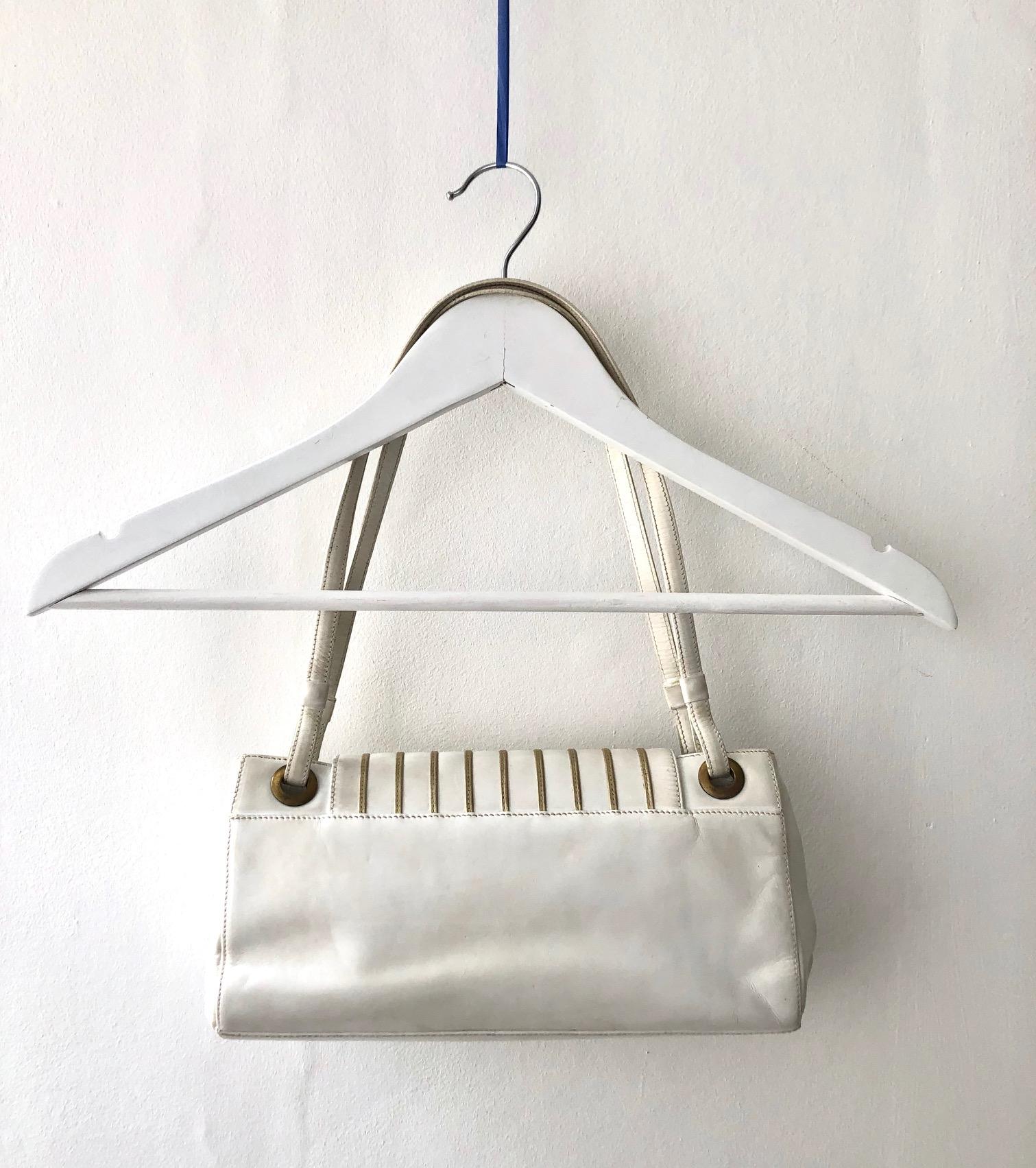 Balmain Paris Handbag White cream Leather, brass metal ware, strong magnetic clasp closure, inside zipped pocket, suede interior This timeless and sophisticated design is crafted from luxurious leather, giving you a stylish and secure accessory that