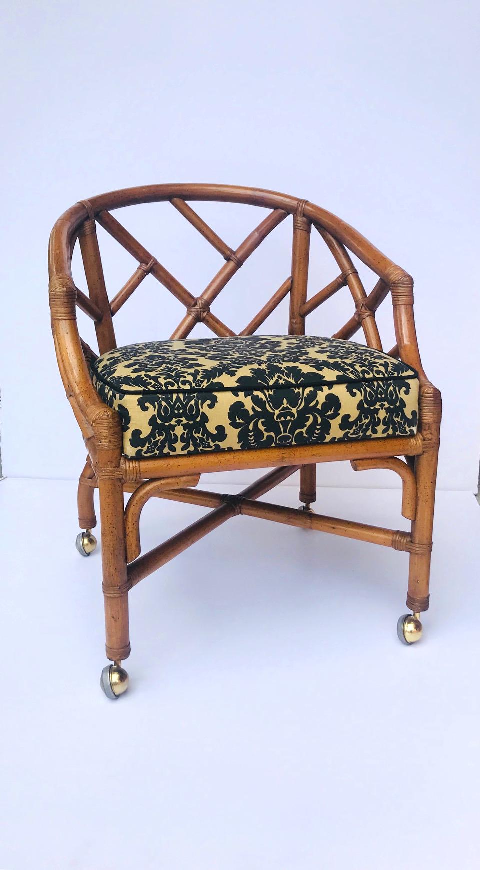 Fabulous Hollywood Regency Chinese Chippendale desk chair. Striking from all angles and easily swivels. Fitted with four brass castors. Upholstered in damask print textile in hues of black over tan, and waterproof.