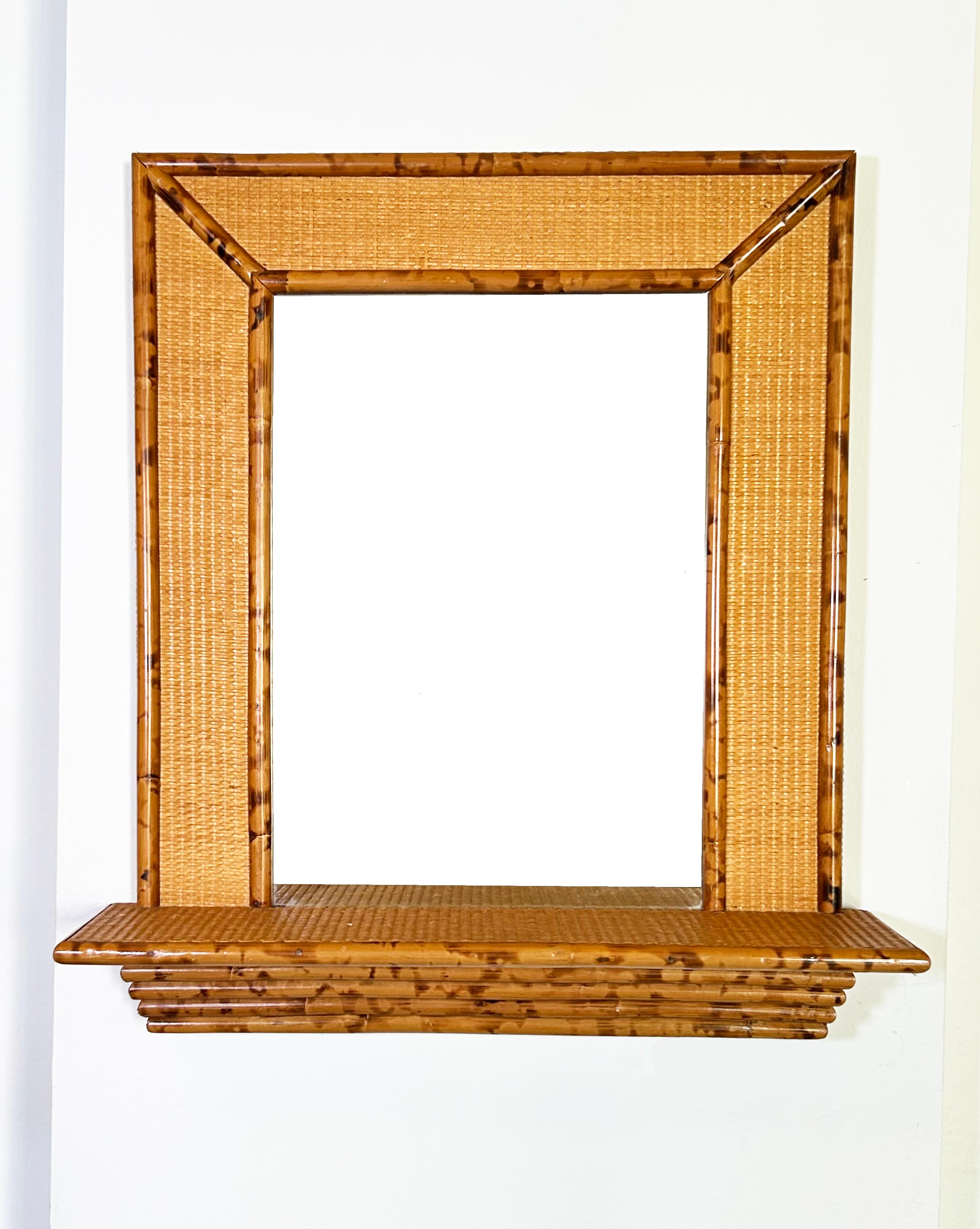 1970s wall mirror with a console shelf, all made of bamboo and rattan.
The frame measures 24