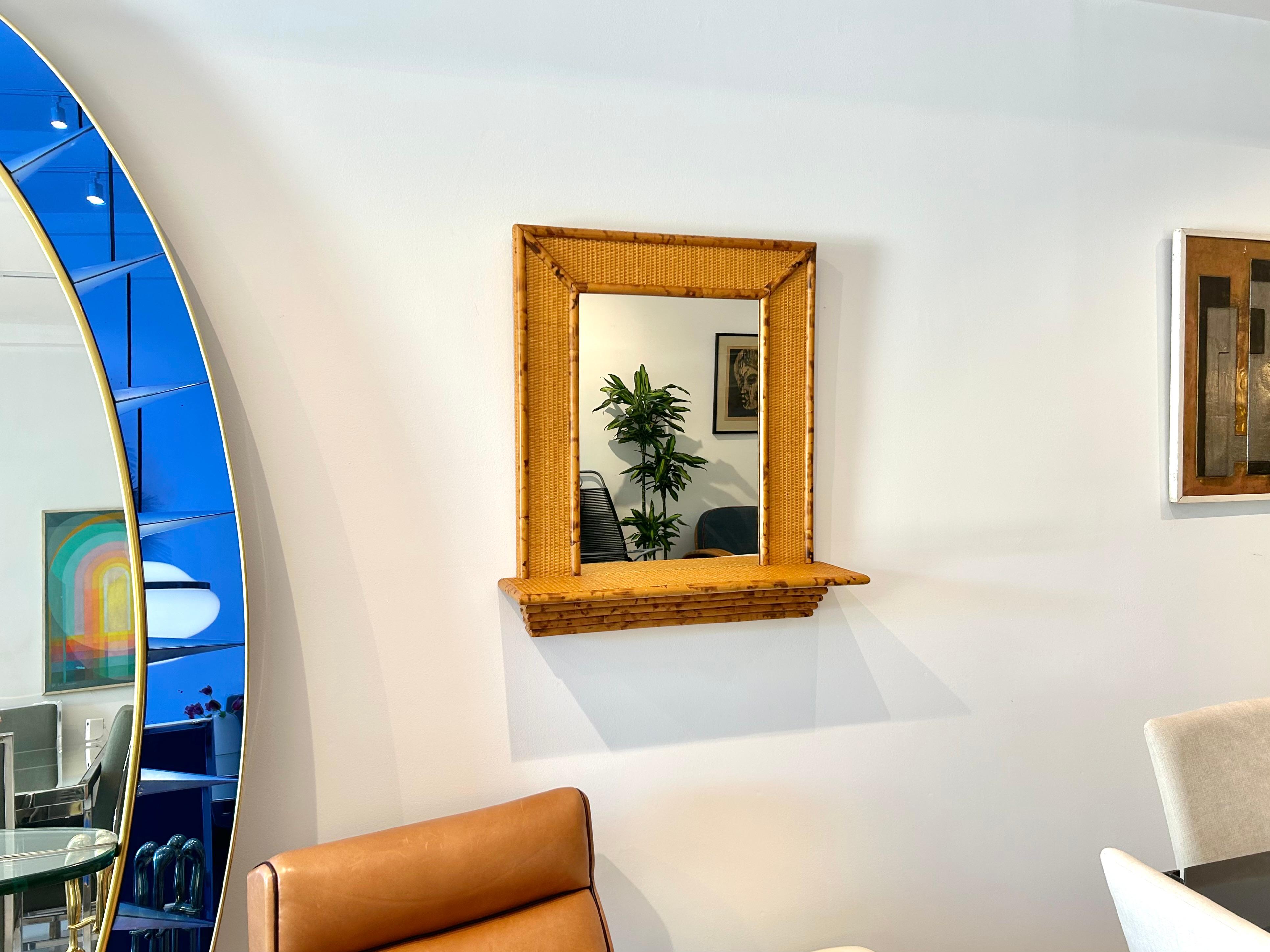 Miroir mural des années 1970 avec une étagère console, le tout en bambou et rotin.
Le cadre mesure 24