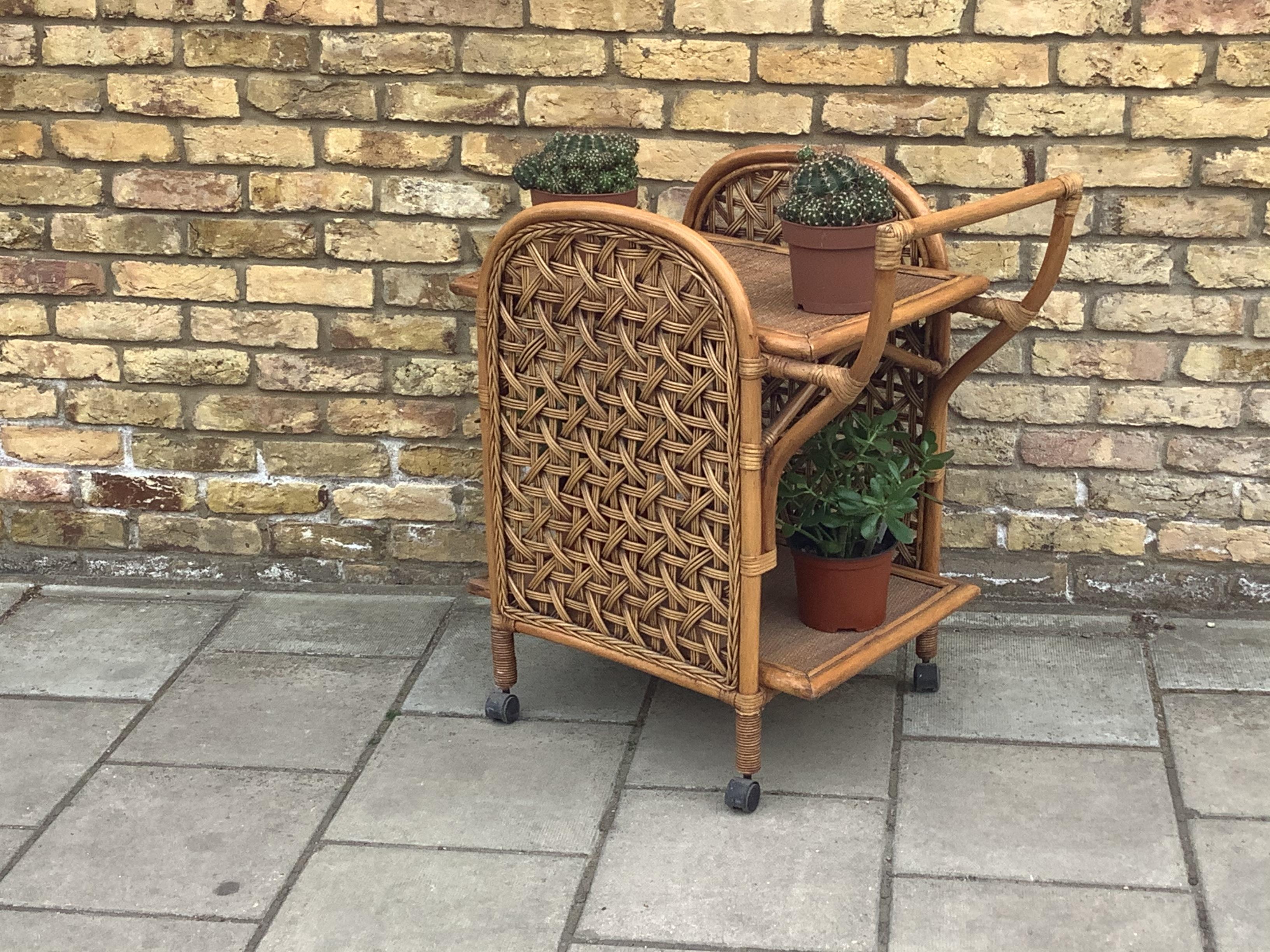 Superb Bamboo and rattan drinks trolley. Good decorative size and shape
On castors and could be used for drinks or plants.
 