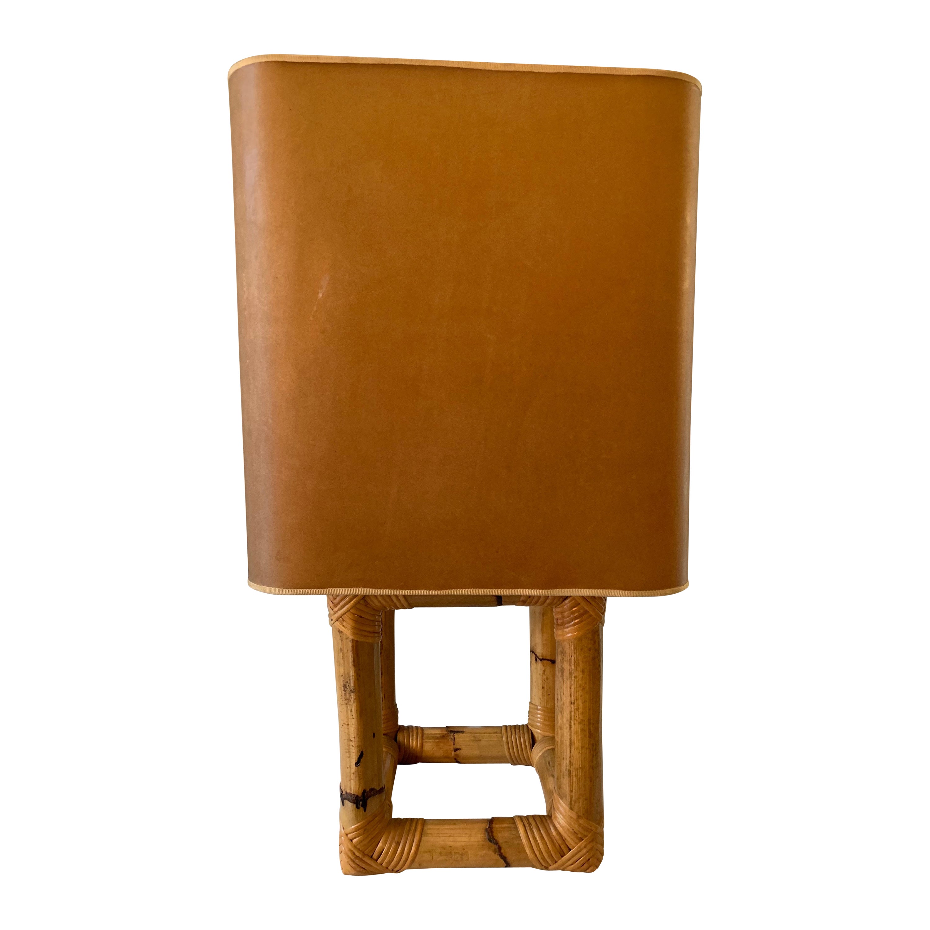 Elegante lampada da tavolo vintage in bambù degli anni '70 con il grande paralume originale in sottile pelle di animale che lascia trasparire la luce in modo caldo e delicato.  