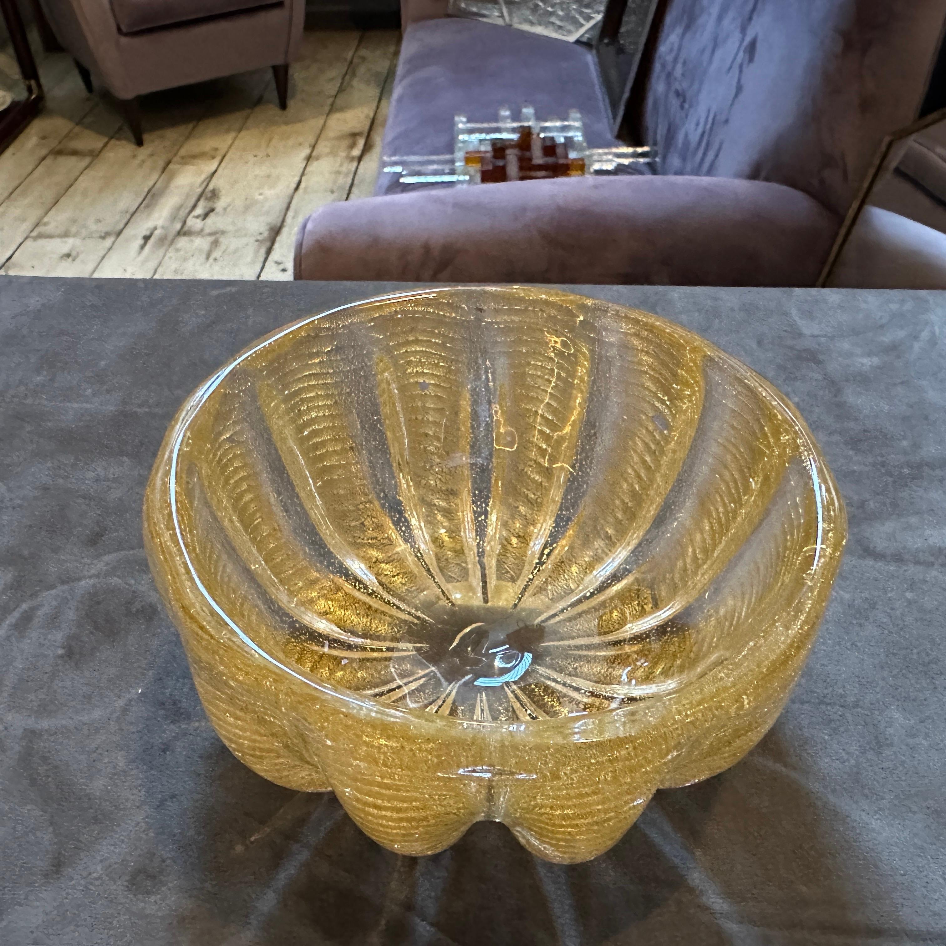 Ciotola rotonda in vetro di Murano trasparente e oro in stile Barovier, vintage anni '70.
Questa splendida ciotola vintage incarna lo stile lussuoso e sofisticato del vetro di Murano della metà del XX secolo, che ricorda i magistrali disegni di
