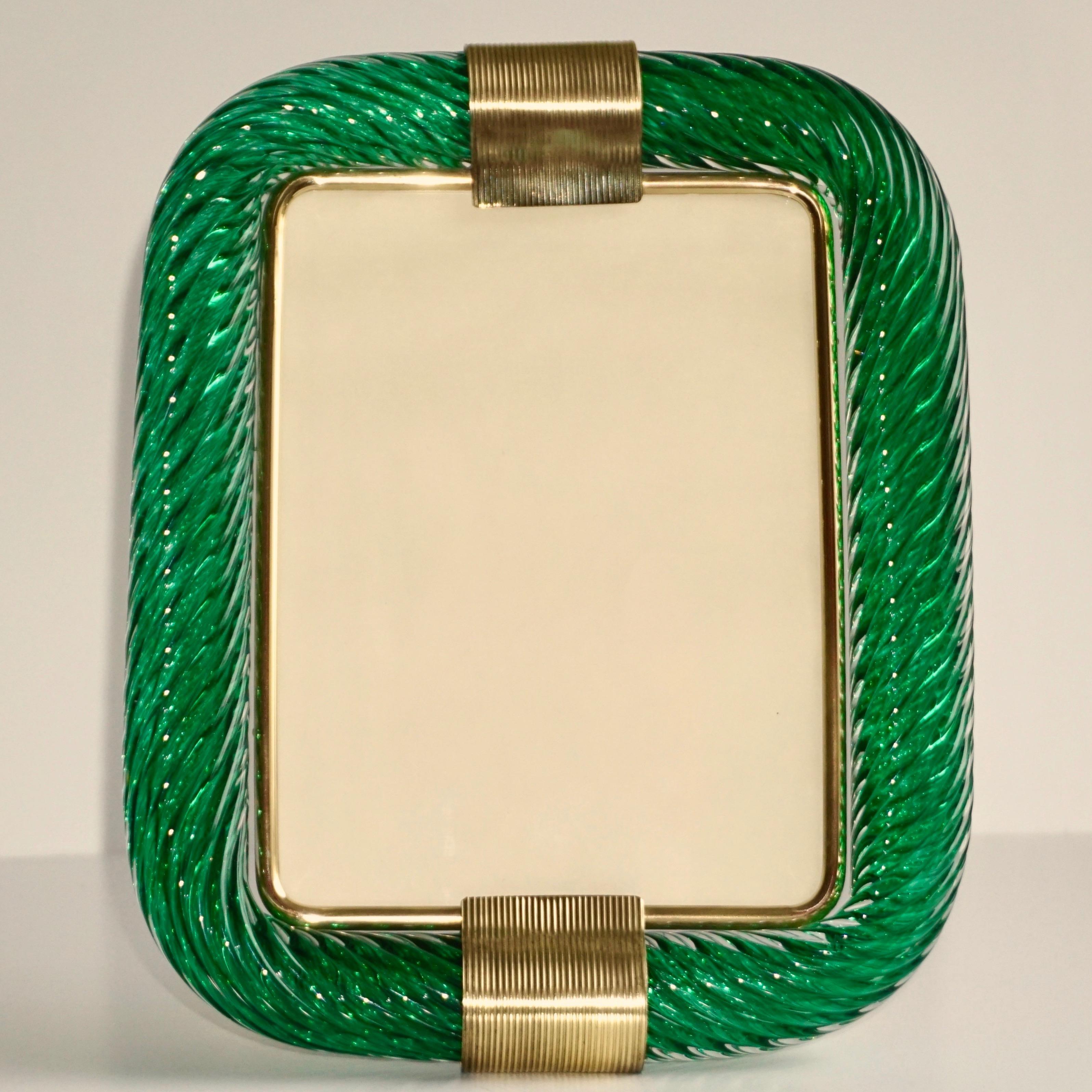 Sophisticated and elegant vintage picture frame of big size, in thick blown Murano glass of attractive glowing forest green color, entirely handcrafted in Italy. The Murano glass frame worked with Torciglione technique, handcrafted twisted blown