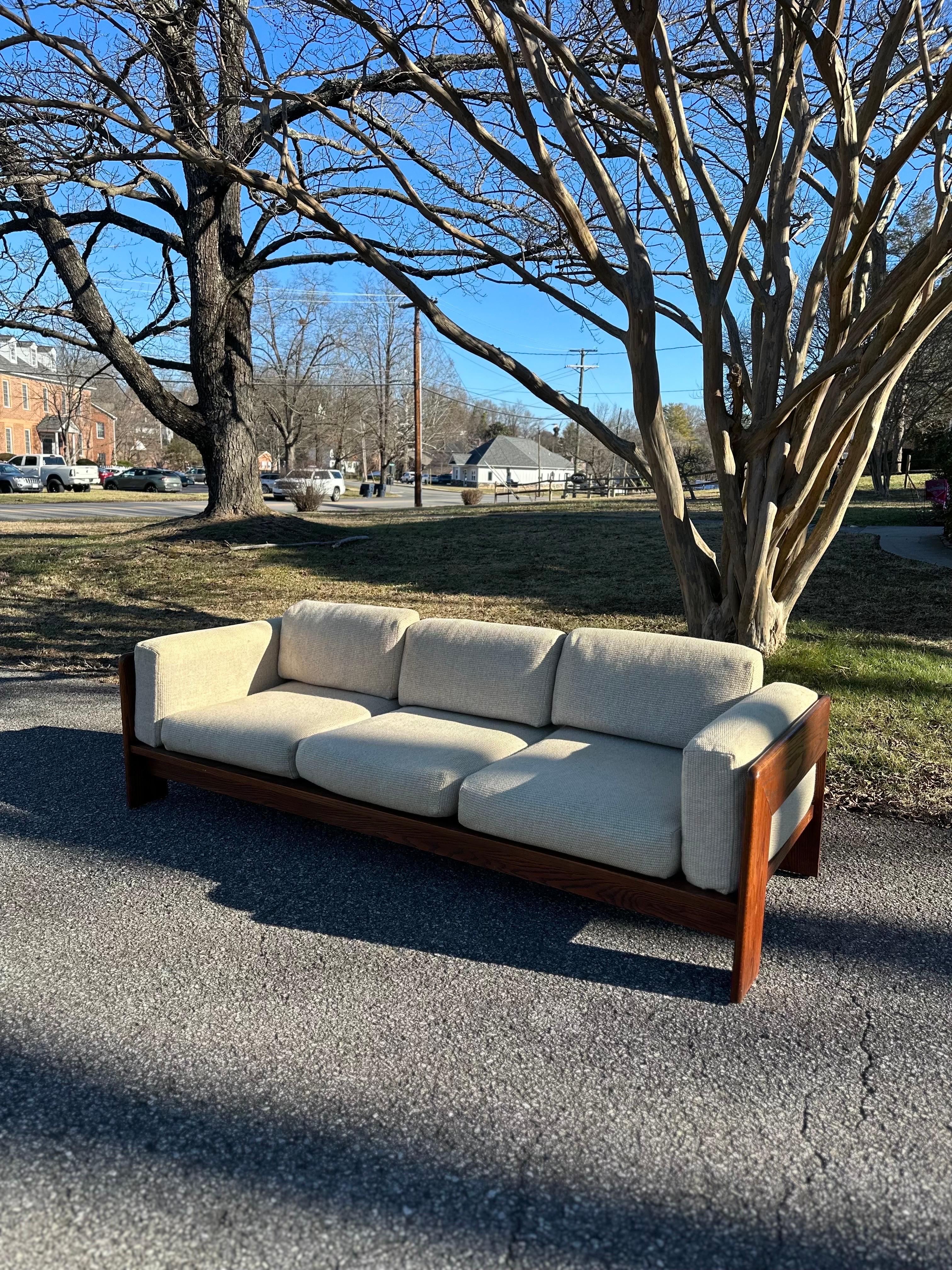 Iconic 1970s three-seater sofa, skillfully attributed to the renowned design duo Afra and Tobia Scarpa. Crafted with a distinctive oak frame and featuring removable cushions, this sofa seamlessly blends style and functionality. The thoughtful