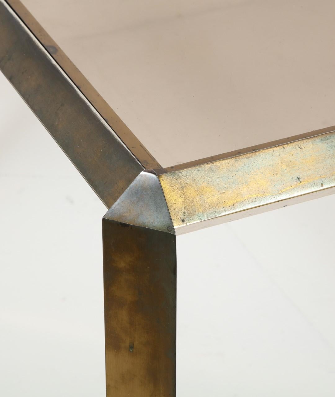 Midcentury 1970s Bauhaus style brass dining table with beveled brass edges around the smoked glass top.