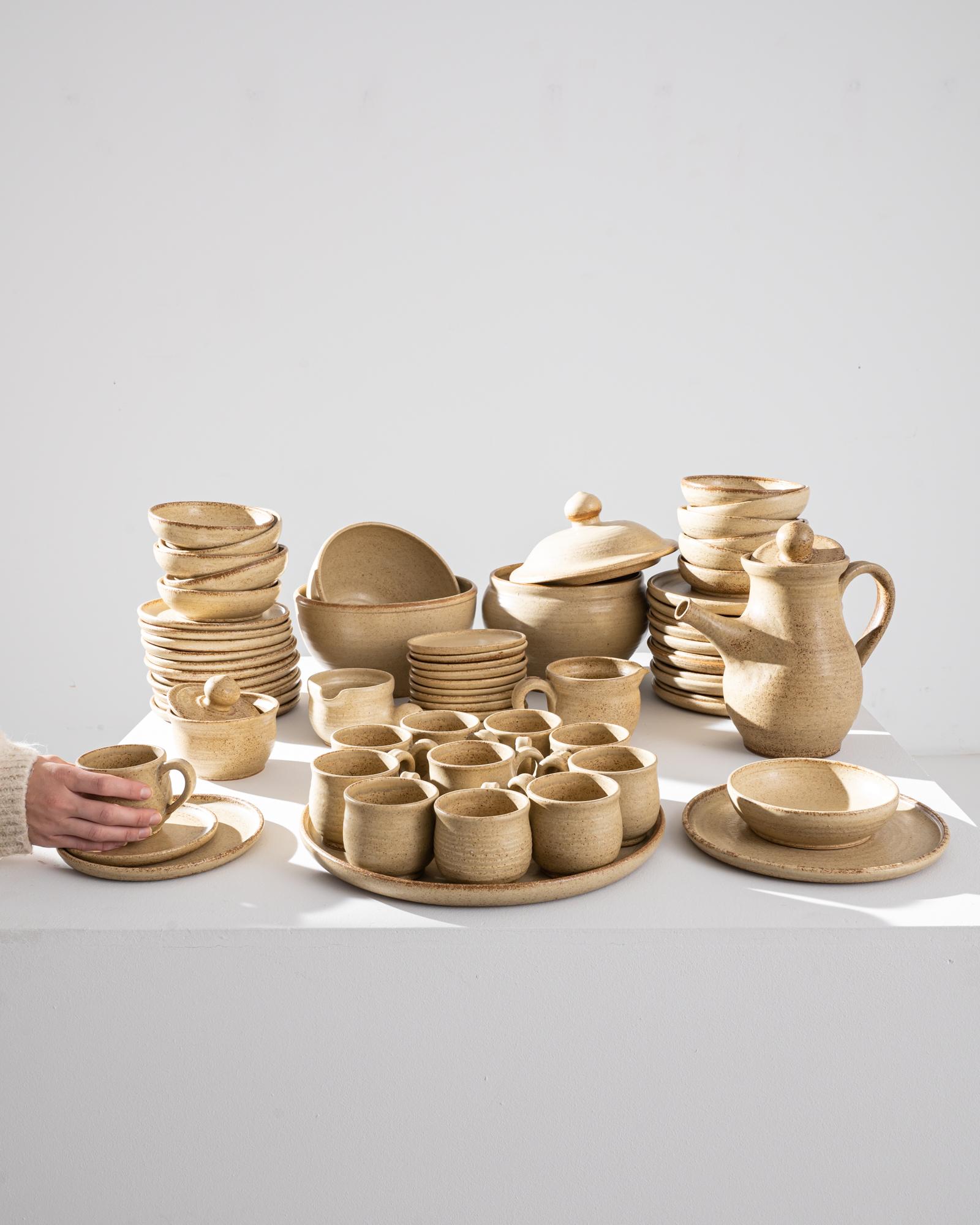 This vintage stoneware dinner set possesses a timeless rustic charm. Made in Belgium in the 1970s, these pieces were fired at high temperatures, granting them durability, longevity, and a distinctive heft. The rounded forms of the cups, bowls,