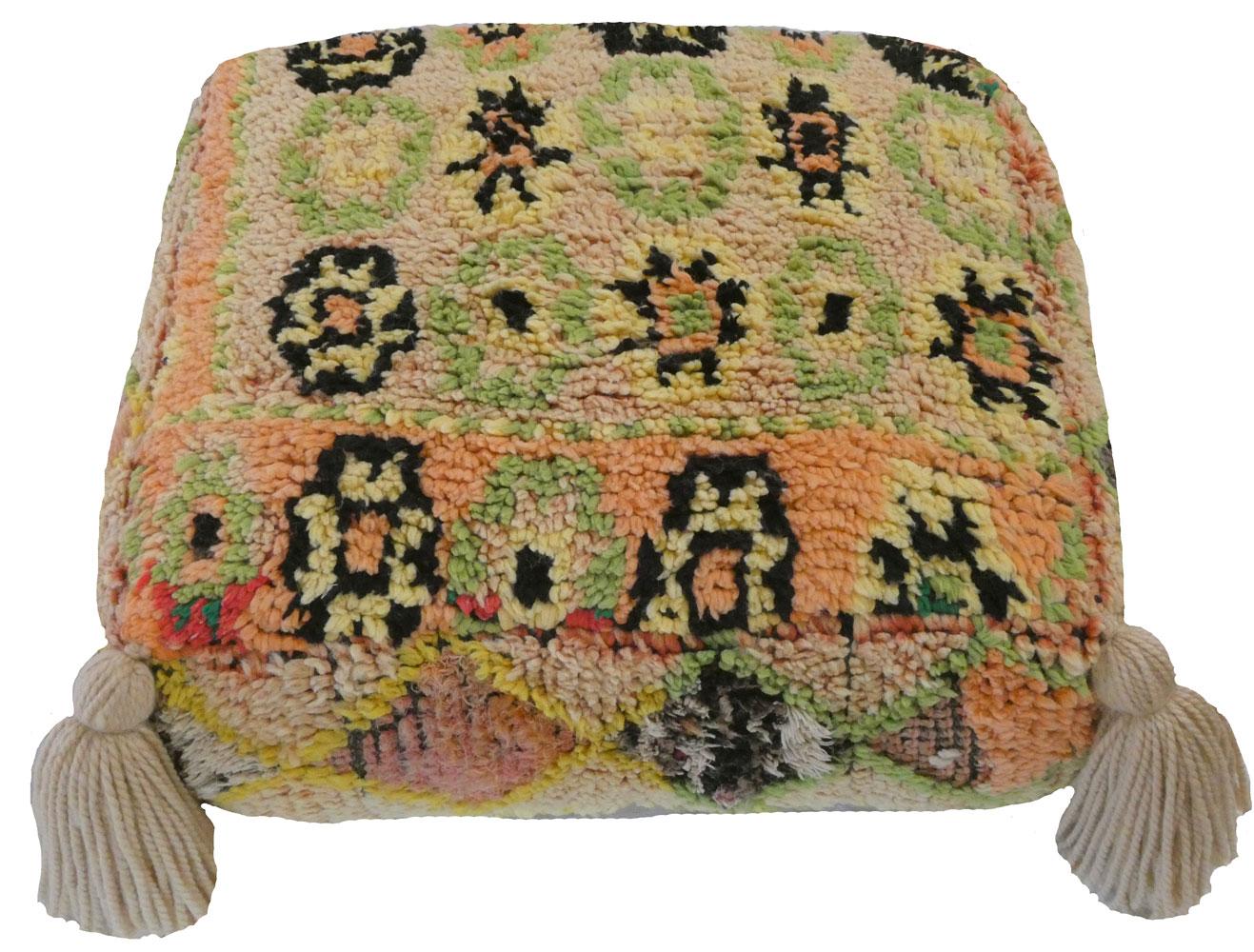 Einzigartiger marokkanischer Vintage-Bodenhocker aus einem wunderschönen handgewebten Teppich aus der Mitte des Jahrhunderts in Creme,  peridotgrüne, gelbe, apricotfarbene und schwarze Wolle. Handgefertigte Quastenakzente und ein Kelim auf der
