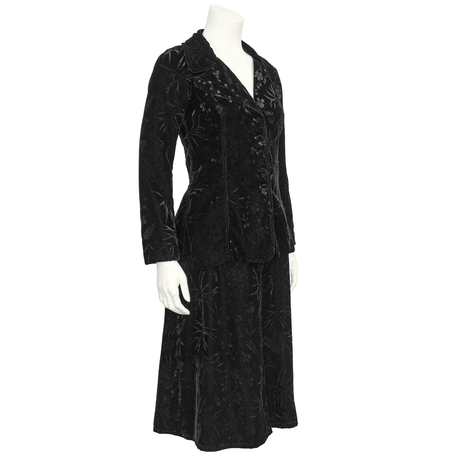 Beautiful Biba jacket and skirt ensemble from the 1970s. Jet black devoree velvet with a floral and leaf pattern throughout. The jacket features a curved notched collar and is fitted through the waist with five velvet covered buttons. The back has a