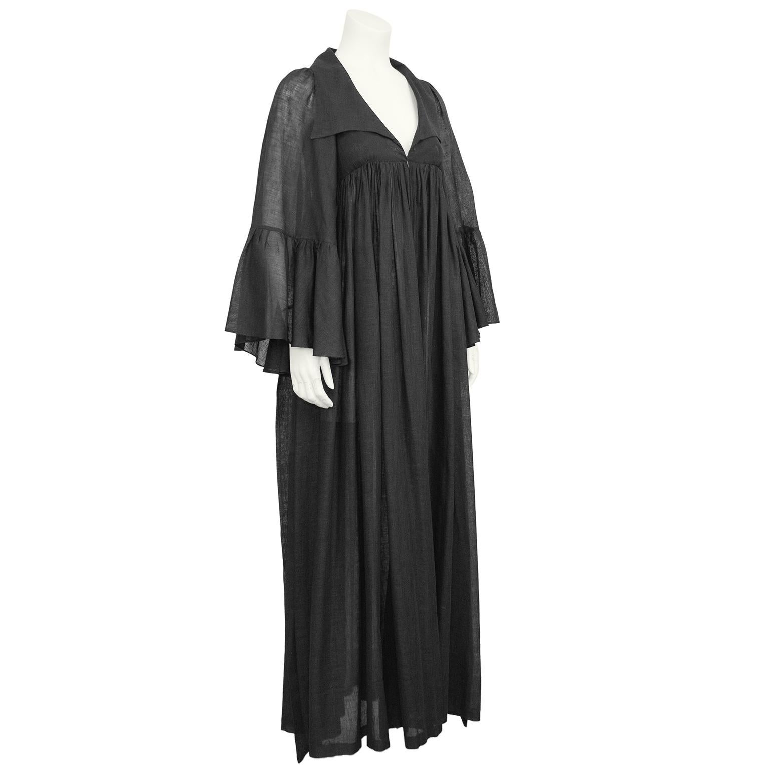 Lovely 1970s hostess gown/duster, from the London based brand Biba. The dress features an open V-neckline with an oversized pointed collar. The sleeves are a wide bell shape was a single tiered ruffle. Gathered empire waist that flows into a long