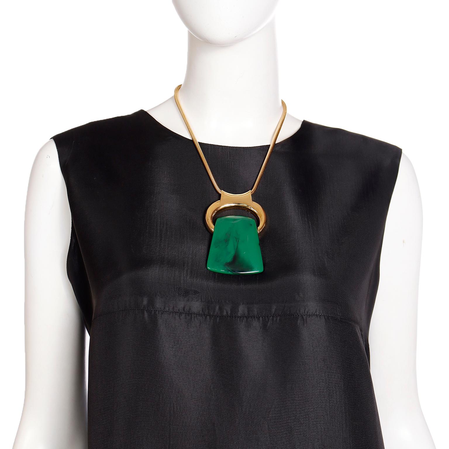 This iconic vintage Bijoux Lanvin necklace from the 1970s is a great set to add to any collection! The gold-plated pendant holder on a snake chain can hold any one of the three interchangeable red, green and brown lucite pendants. The bale on the