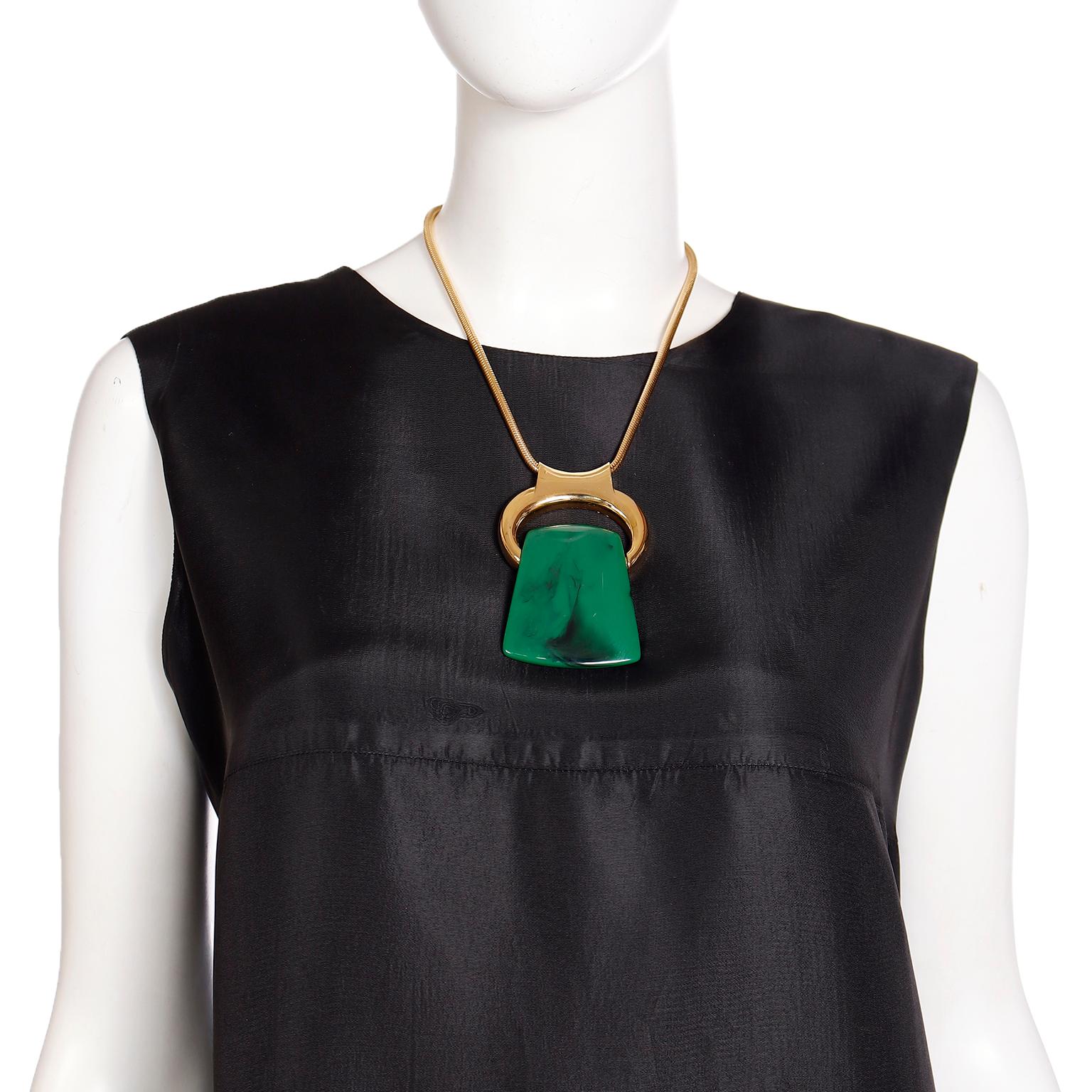 Ce collier iconique Bijoux Lanvin vintage des années 1970 est un superbe ensemble à ajouter à toute collection ! Le porte-pendentif plaqué or sur une chaîne serpent peut accueillir l'un des trois pendentifs interchangeables en lucite rouge, verte et