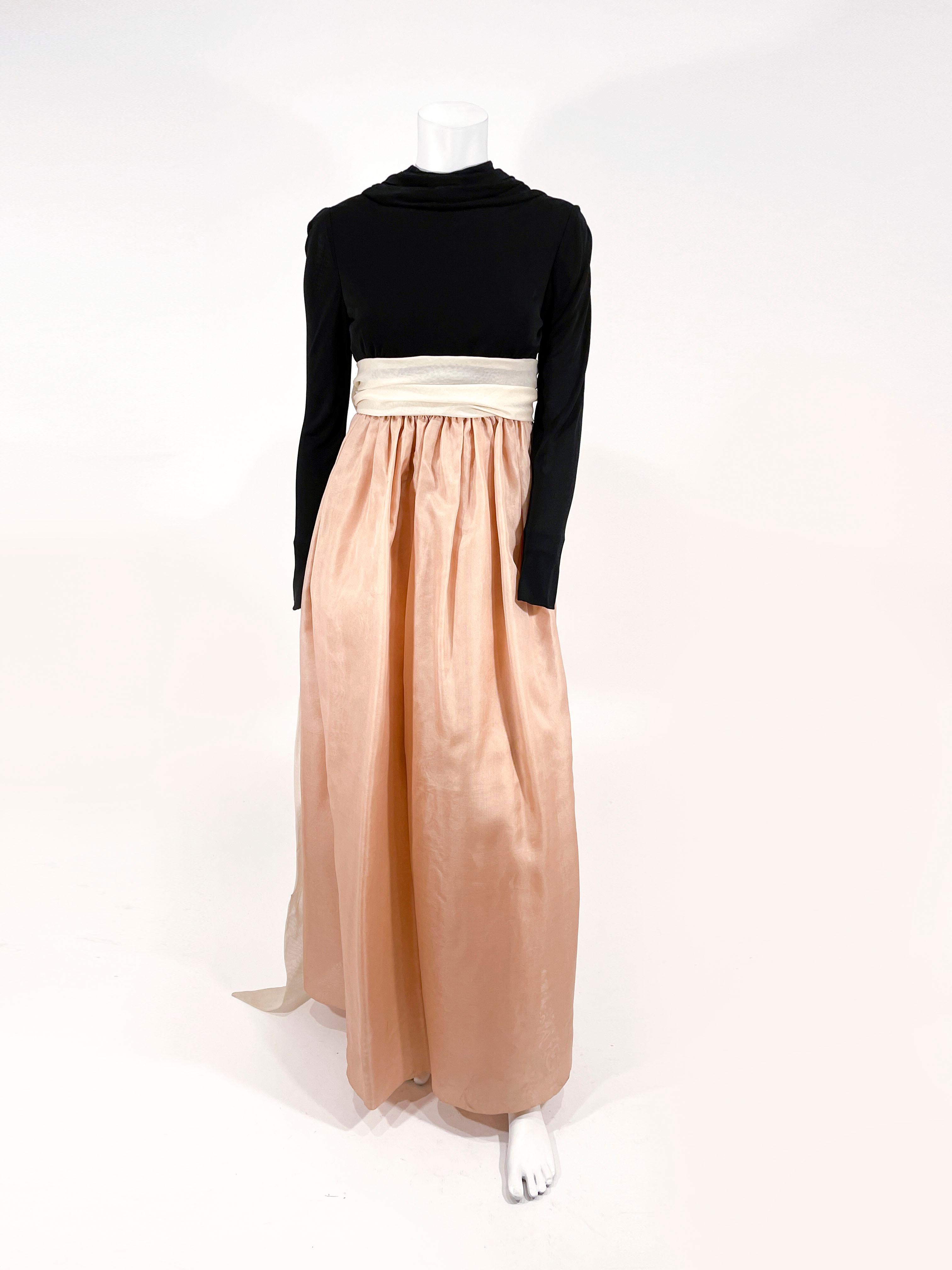 Late 1970s Bill Blass full length gown with a silk jersey bodice featuring a high gathered neckline that complements the long sleeves. The full length tan organza skirt is gathered around the waist and has an attached wide beige was it sash that