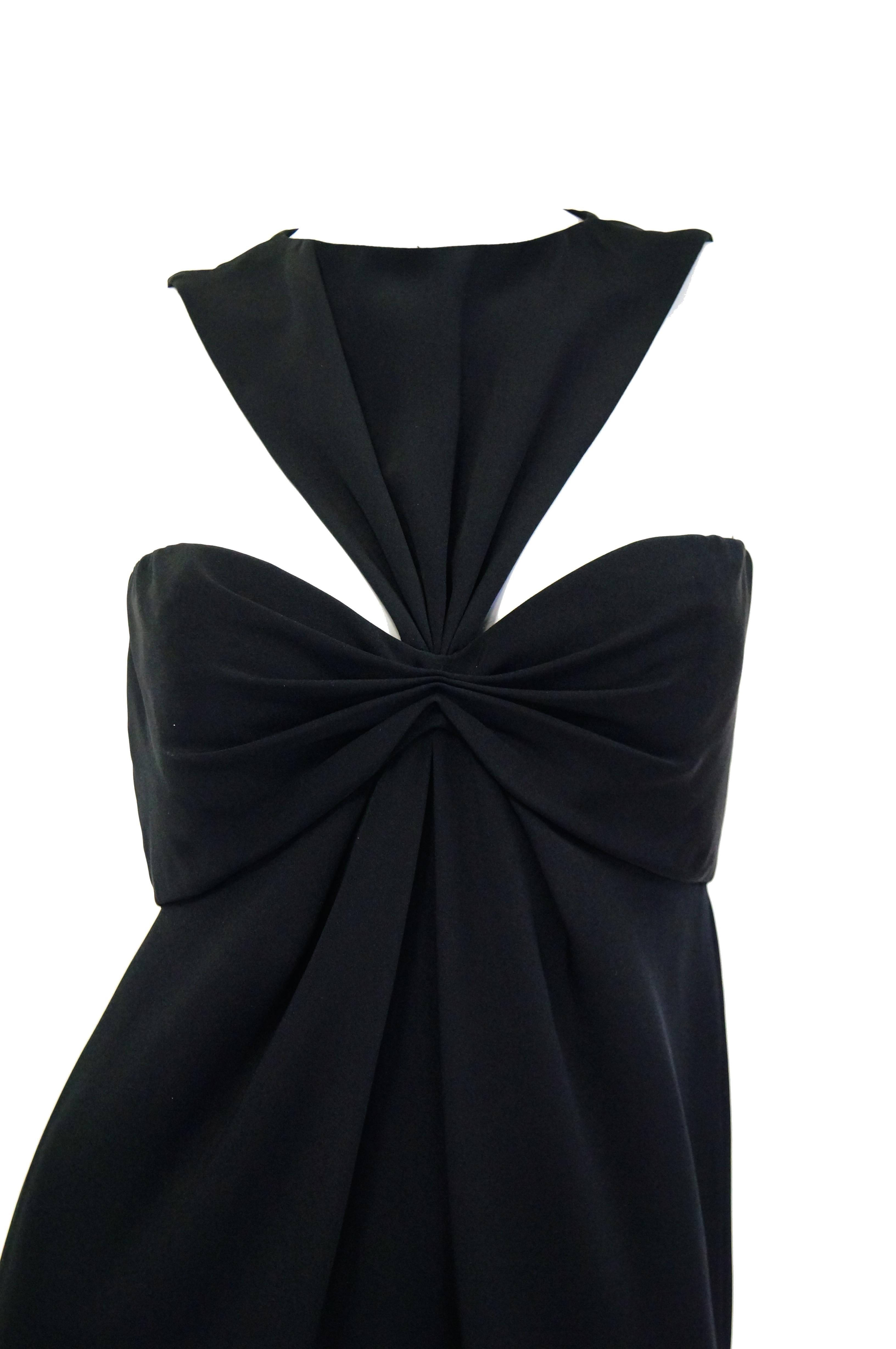 Elegant and unusual cocktail dress by Bill Blass. The dress is knee length, with a fitted silhouette, and sleeveless. The dress has an empire - like shape, with a figure - eight sweetheart bust line that attaches to the remarkable reverse - V -