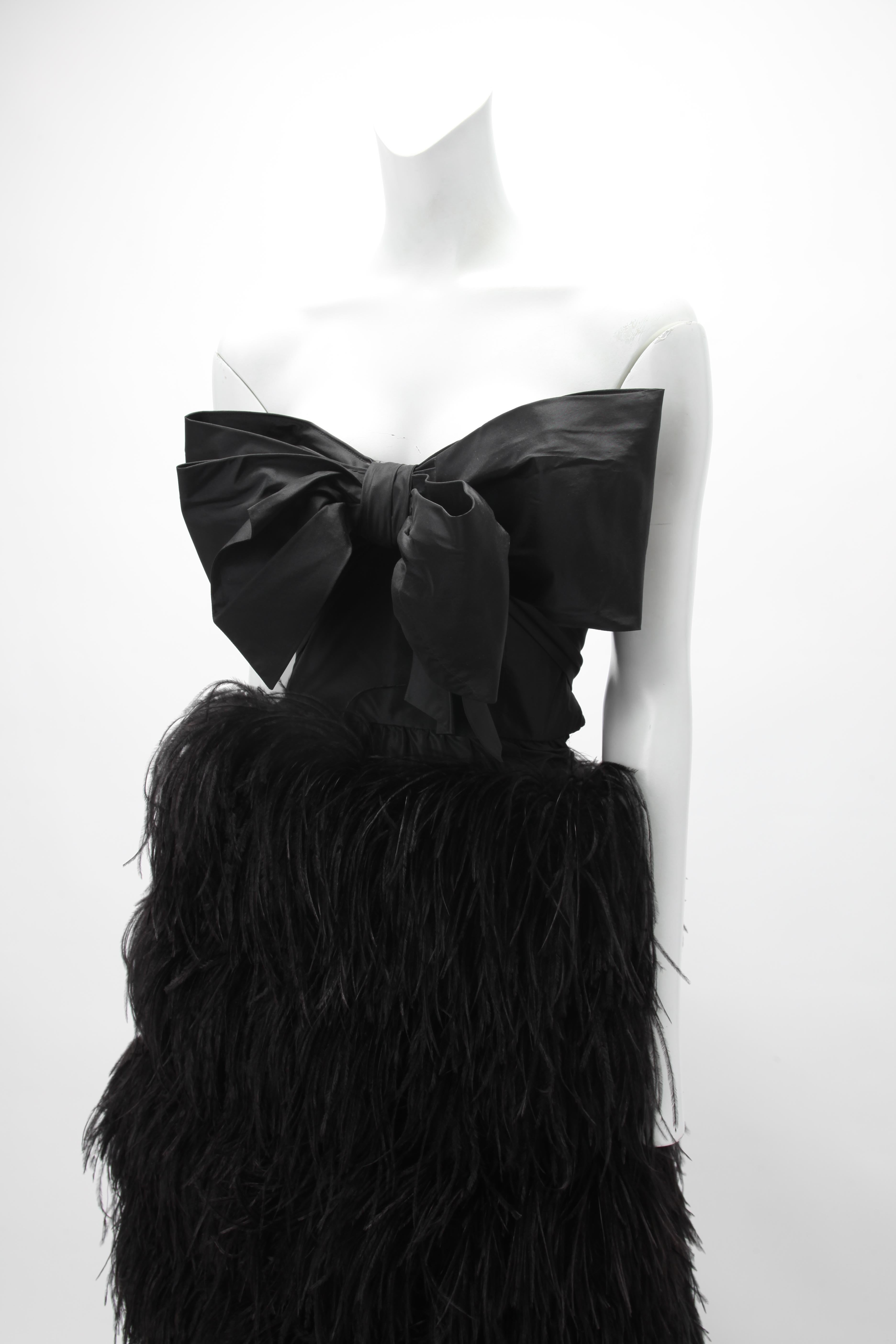 Robe bustier en taffetas de soie noire des années 1970 de Bill Blass ; corsage ajusté et désossé avec nœud surdimensionné ; jupe en cascade en plumes d'autruche.