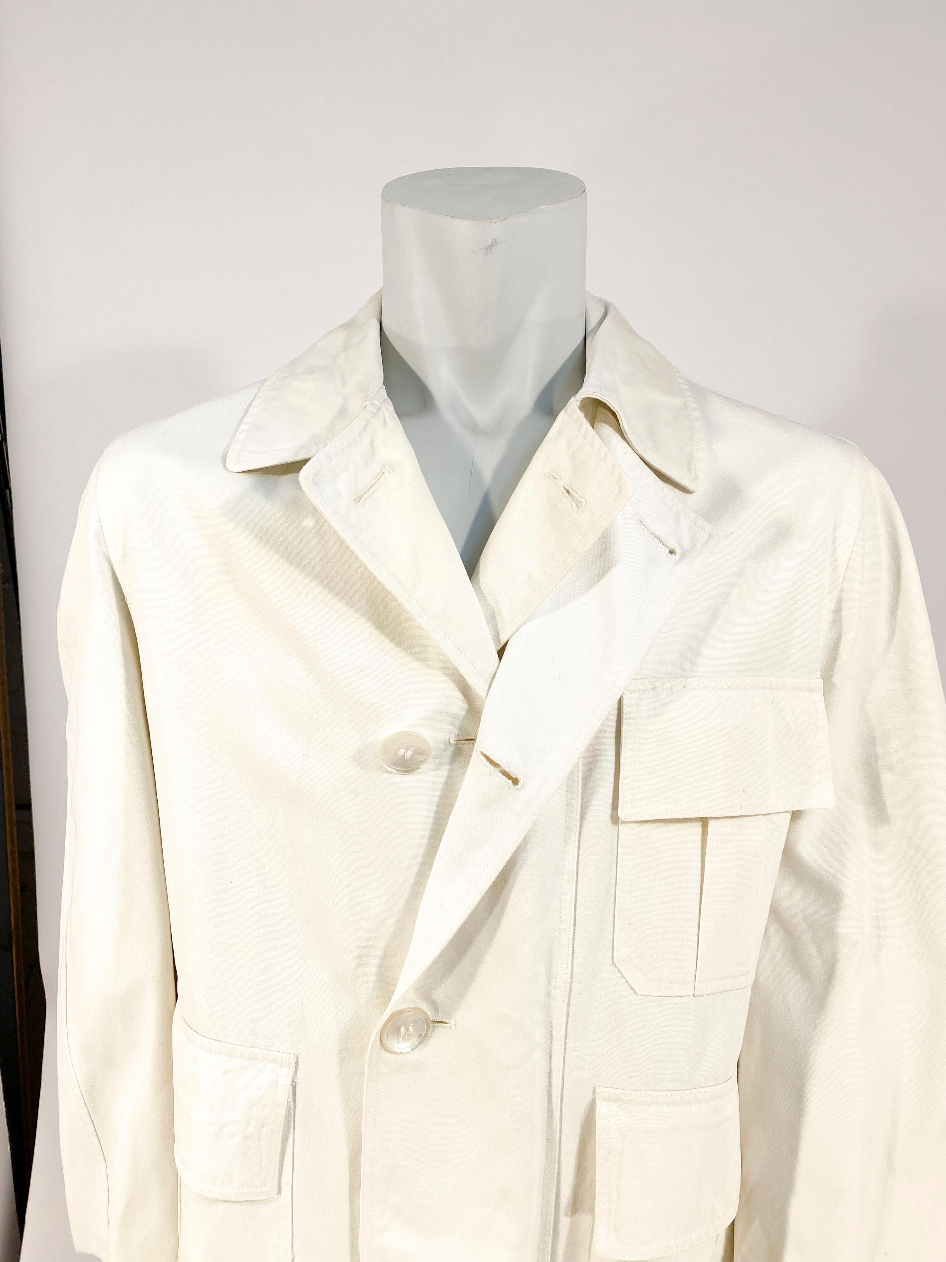 1970s Bill Blass white canvas trench coat with functional button rain flap, full lining, and large pockets.