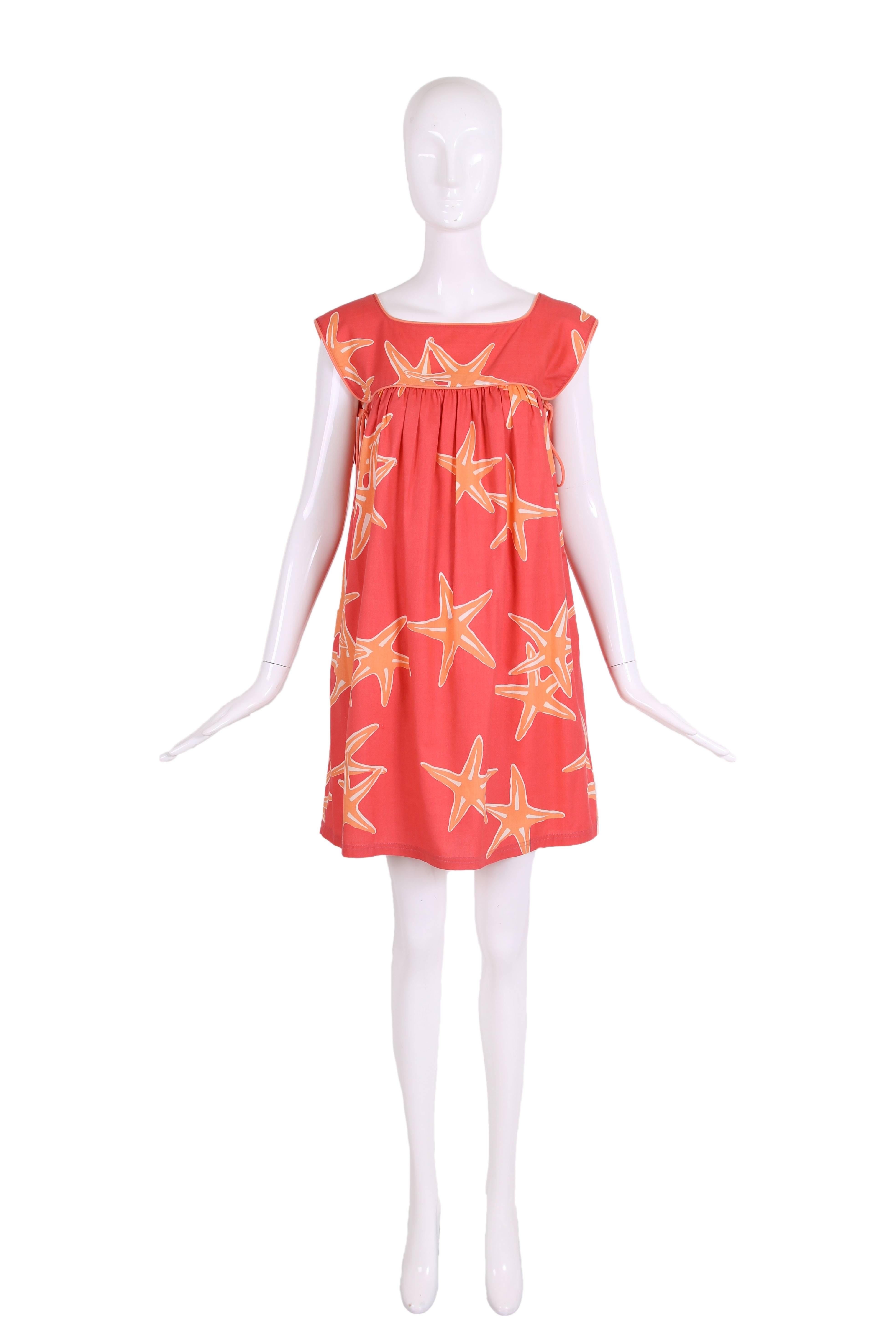 Vintage Bill Tice sleeveless babydoll cotton sundress in coral, orange, and white starfish print. This dress features coral-colored string ties at each under arm and two side pockets. In excellent condition. No size tag, please consult measurements.