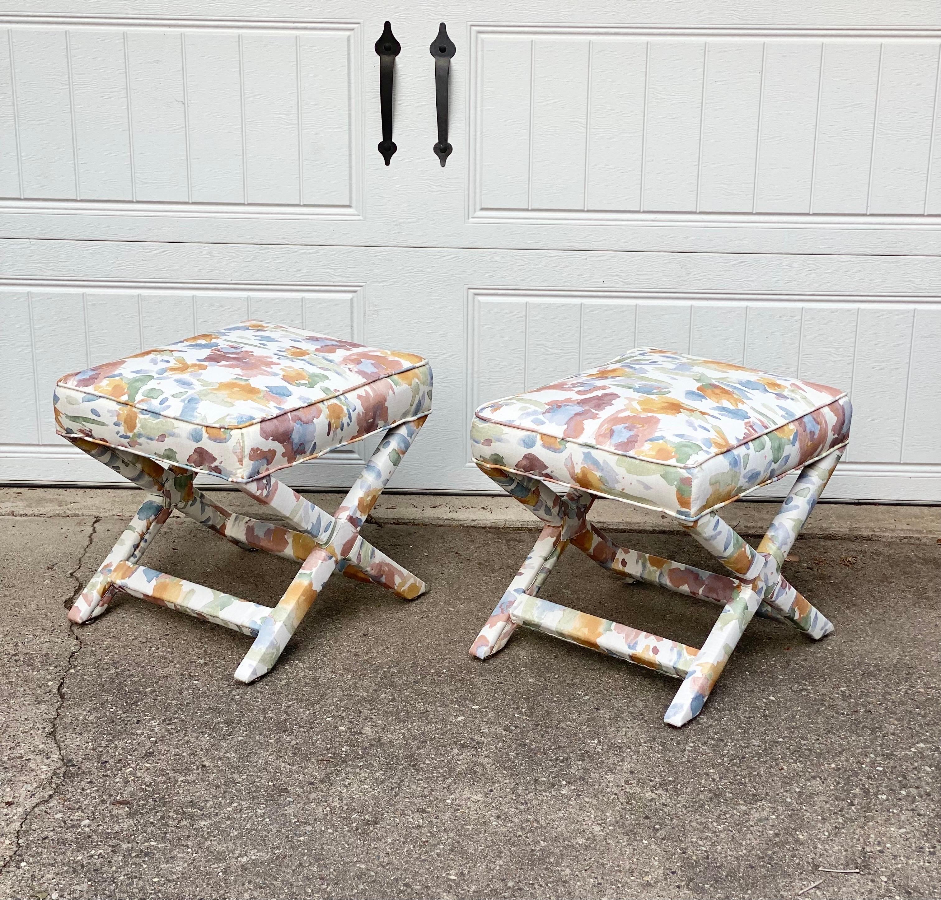 We are very pleased to offer a pair of X-benches in the style of Billy Baldwin, circa the 1970s. Elevate your living space with these captivating ottomans that have been beautifully reupholstered in a timeless delicate floral print fabric. The