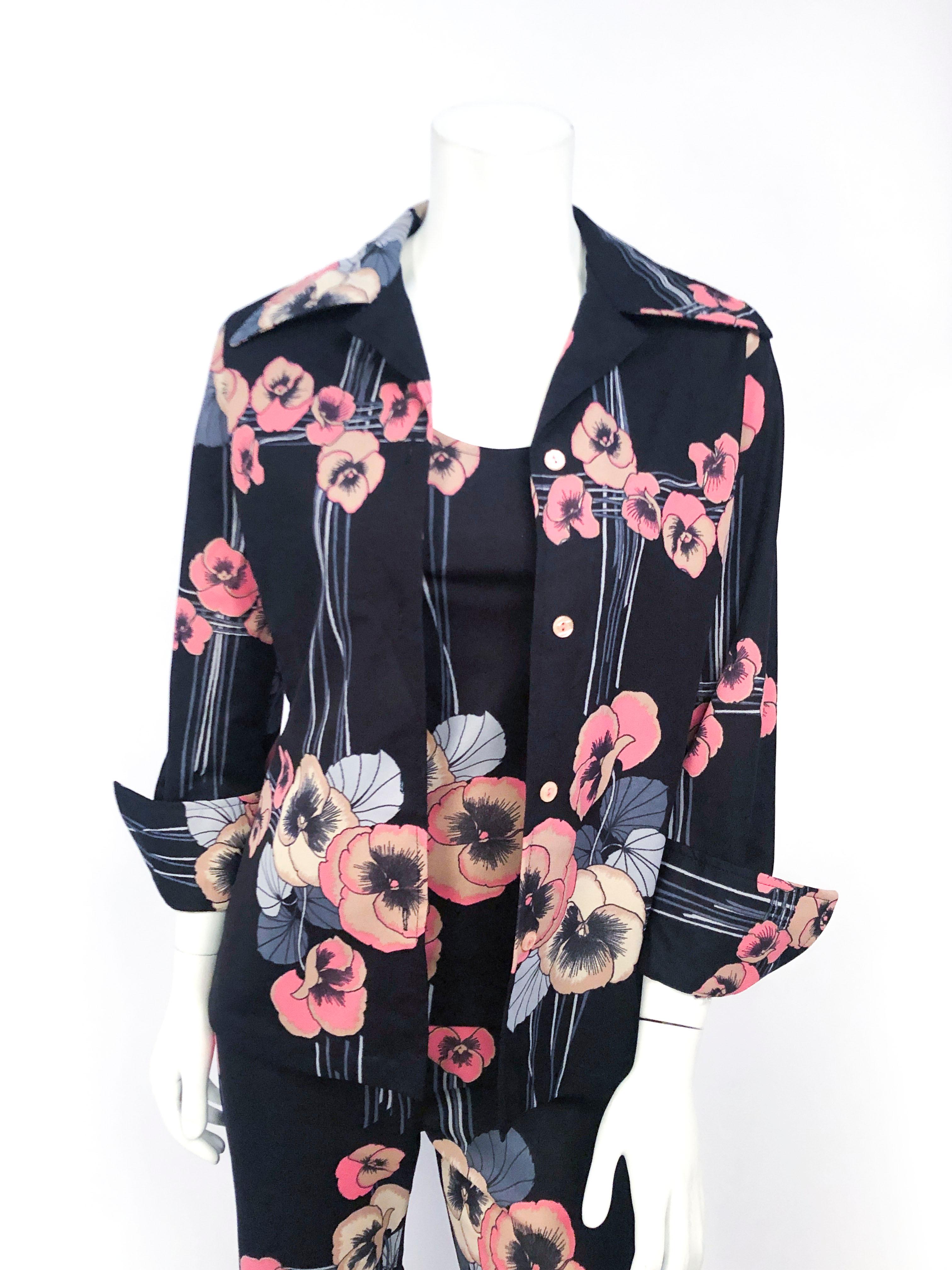 1970s black 3-piece set (shirt jacket, blouse, and pants) with stripe and floral pattern in different tones of blue and soft pinks. Shirt jacket has a wide butterfly collar and folded cuff sleeves. The blouse is a sleeveless tank top and the wide