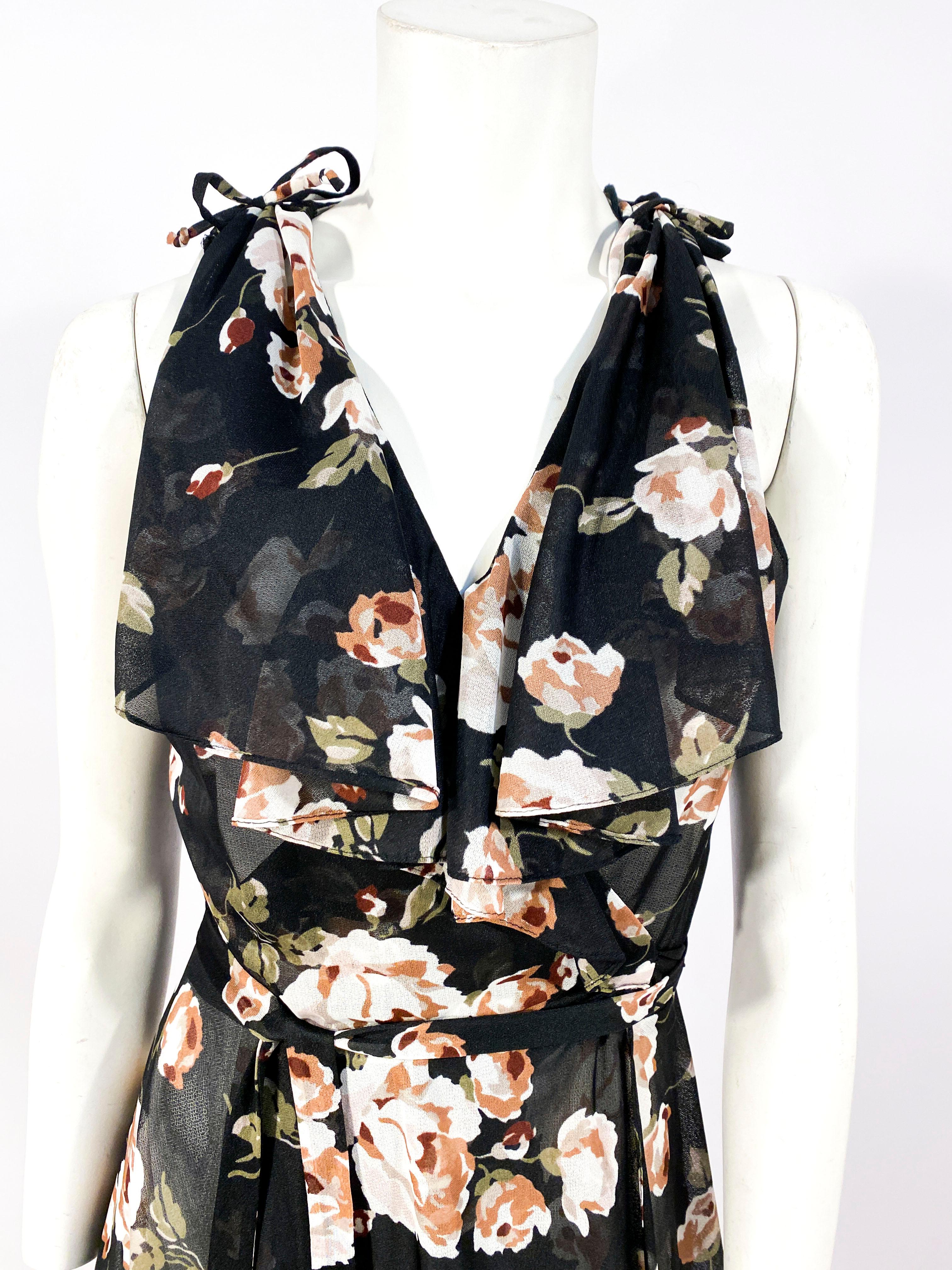 1970s black with floral print wrap dress with 1930-style neckline with drapes and faux cape in the back of the dress. The skirt is full with a slight taper to the hem. Since this is a wrap dress it can accommodate a range of sizes (approx. a US size