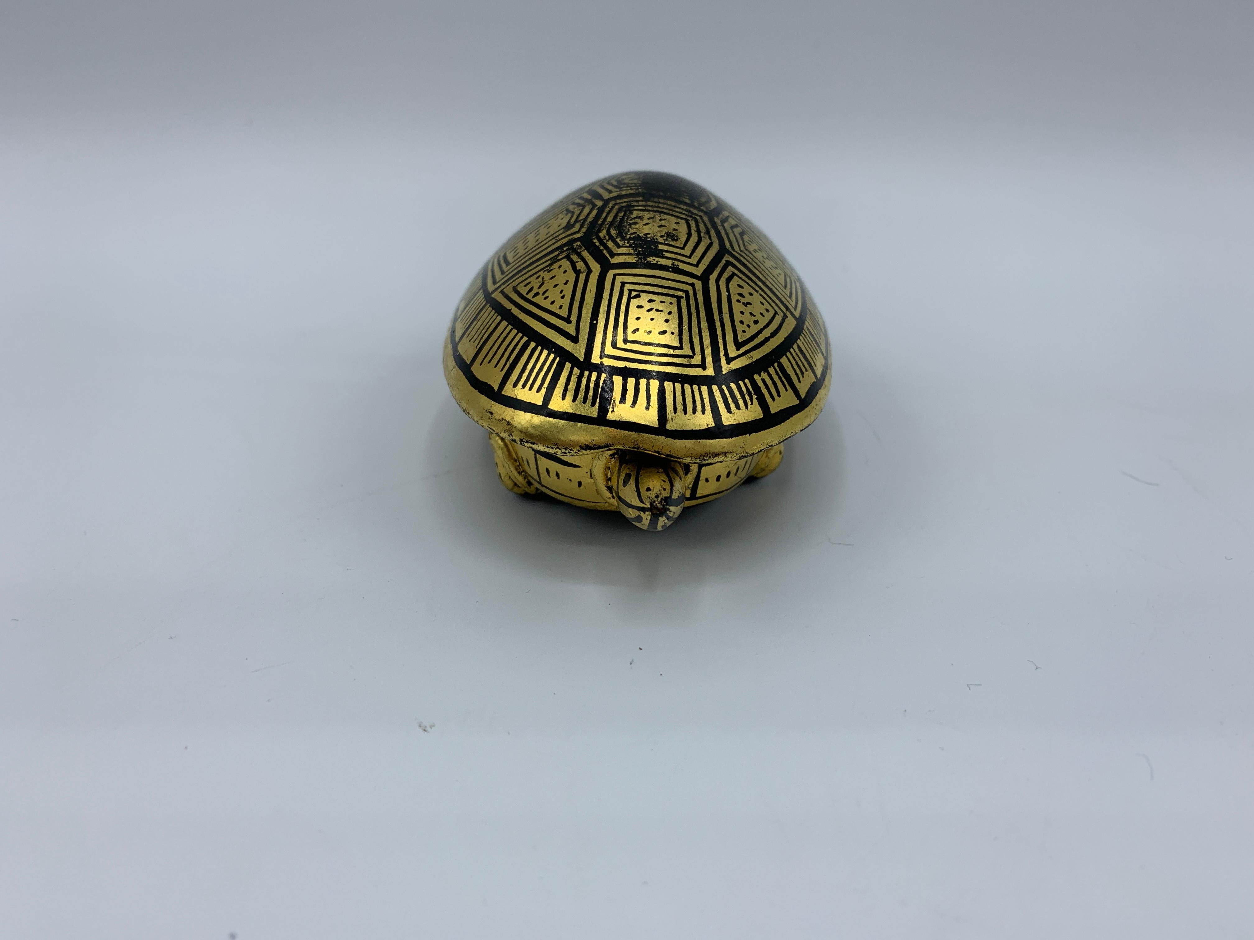 Offered is a gorgeous, 1970s chinoiserie black and gold, lacquered turtle shaped box. The turtles shell is removable, allowing access to the inner box. Perfect as a ring box or a sculptural piece.

             