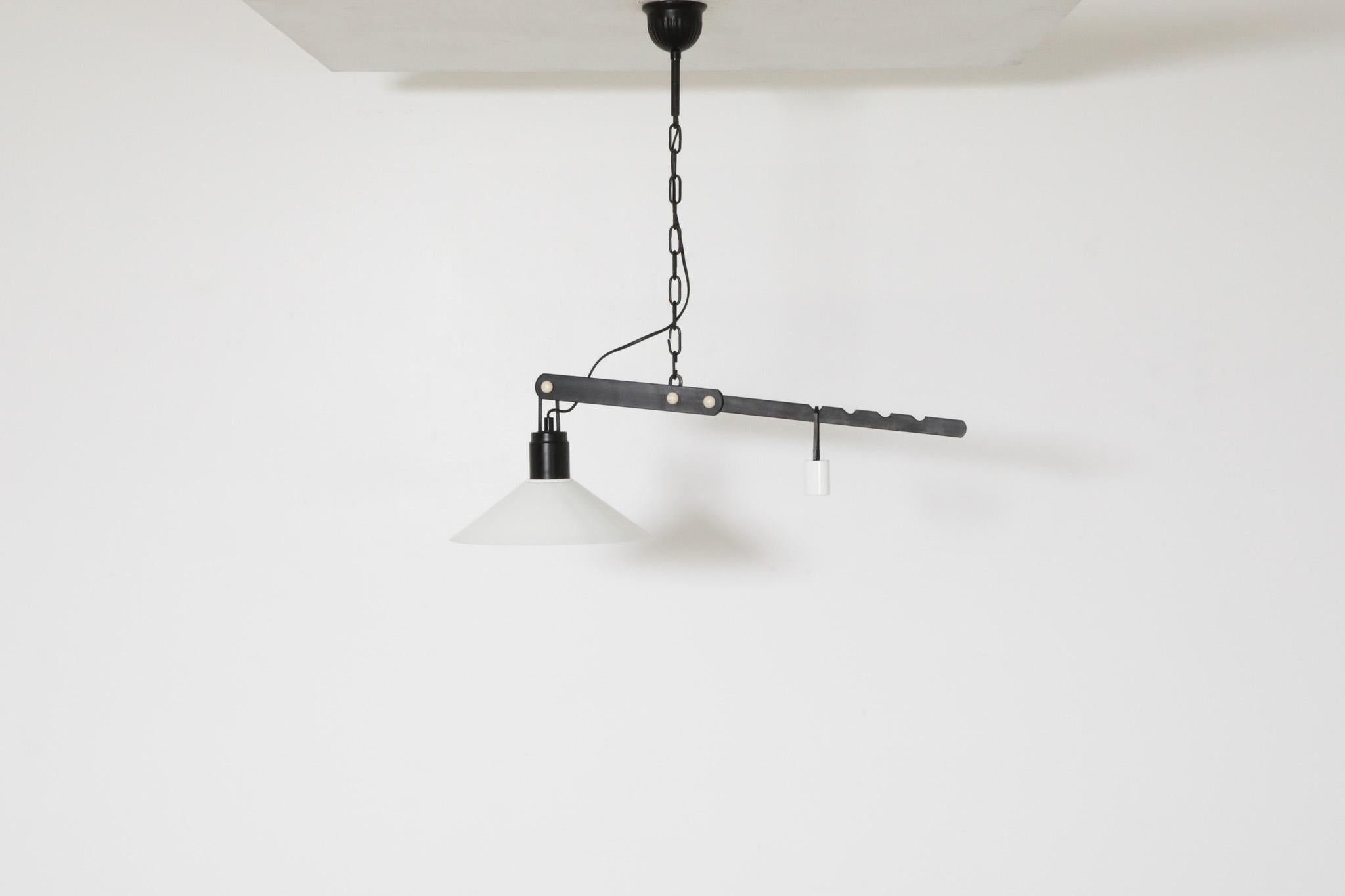 1970s Belgian counterbalance lamp with white enameled metal shade on black base metal and chain. An incredible mix of classic styling and unique artistry this pendant is adjusted by moving the counter weight up or down the notches on its base. this
