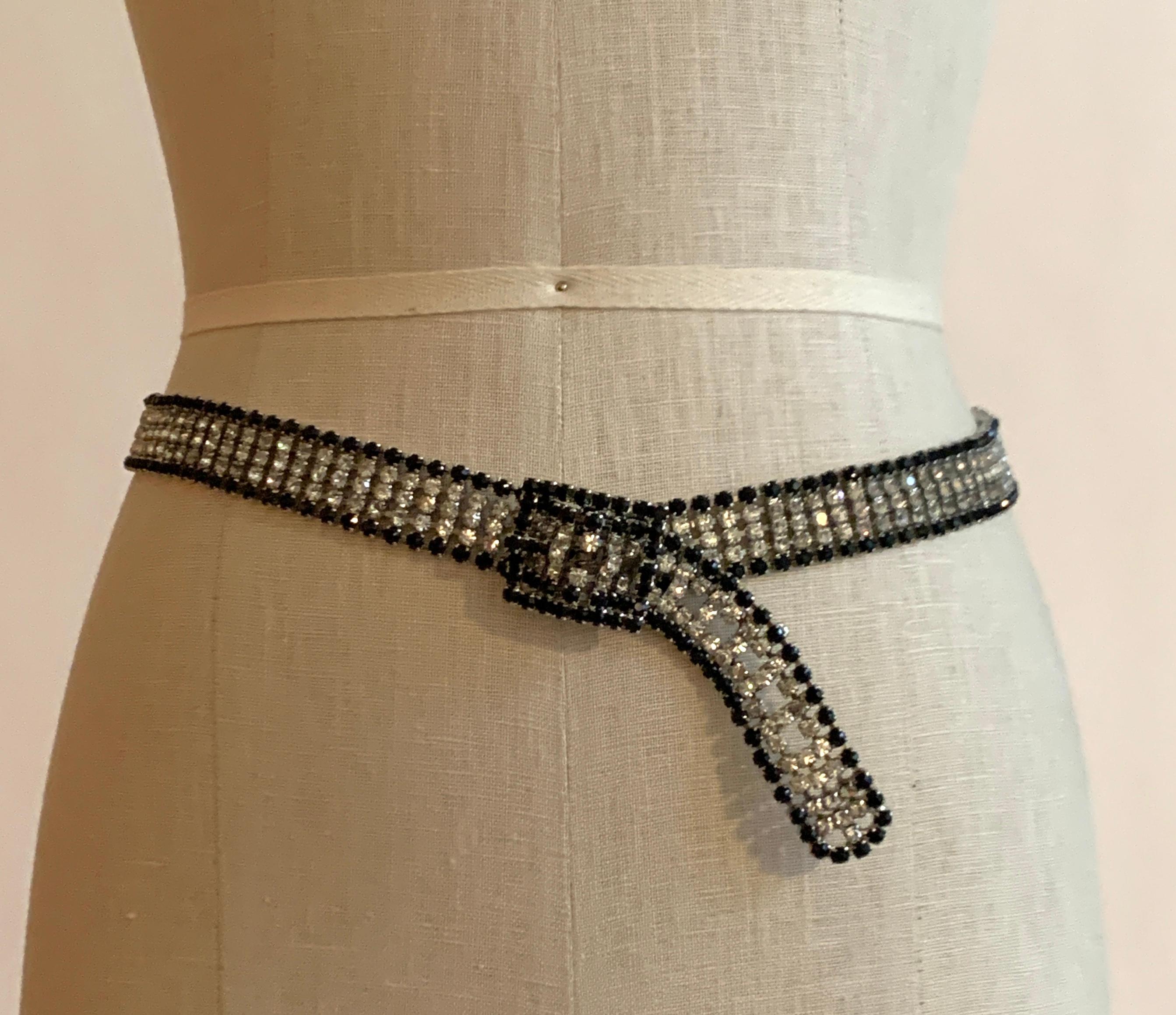 Amazing vintage metal belt (estimated circa 1970s) featuring clear/white rhinestones with a black rhinestone border set in silver tone metal. Buckle closure. 

Perfect for making a plain evening gown a little more special! 

Closure can be adjusted