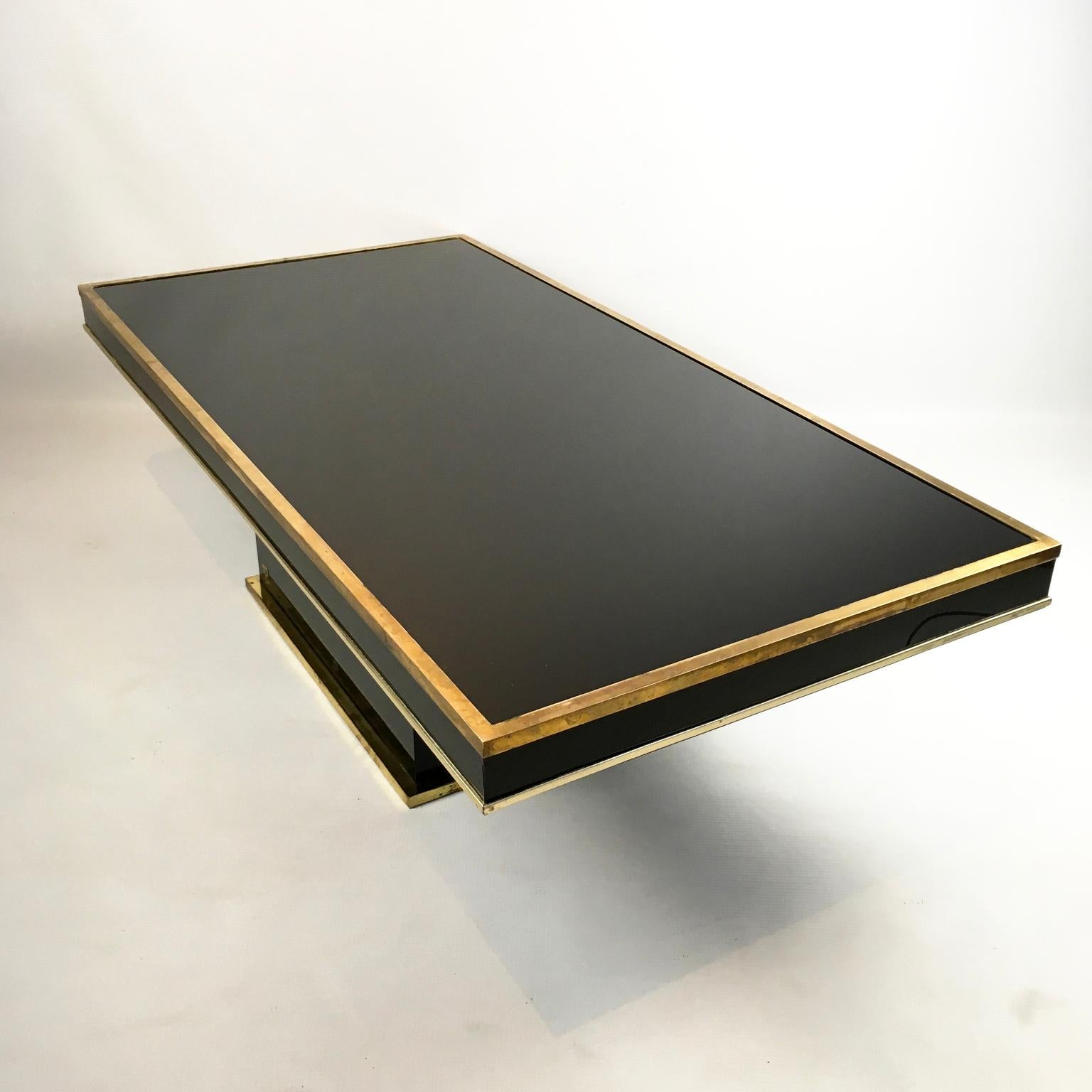 1970s Eric Maville coffee table with a black glass top and brass frame for Maison Roméo
Possibly in association with the designer Jean Claude Mahey.
Unfortunately, the brass 