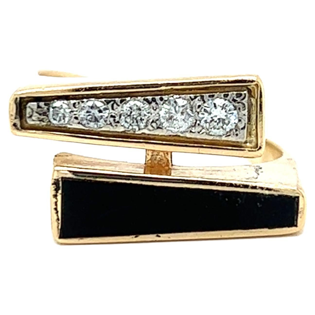 One 14 karat yellow gold bypass design ring set with one black coral tapered baguette tablet measuring 14.5x3.5mm and five (5) round brilliant cut diamonds, approximately 0.10 carat total weight with matching I/J color and Si1 clarity. The ring is