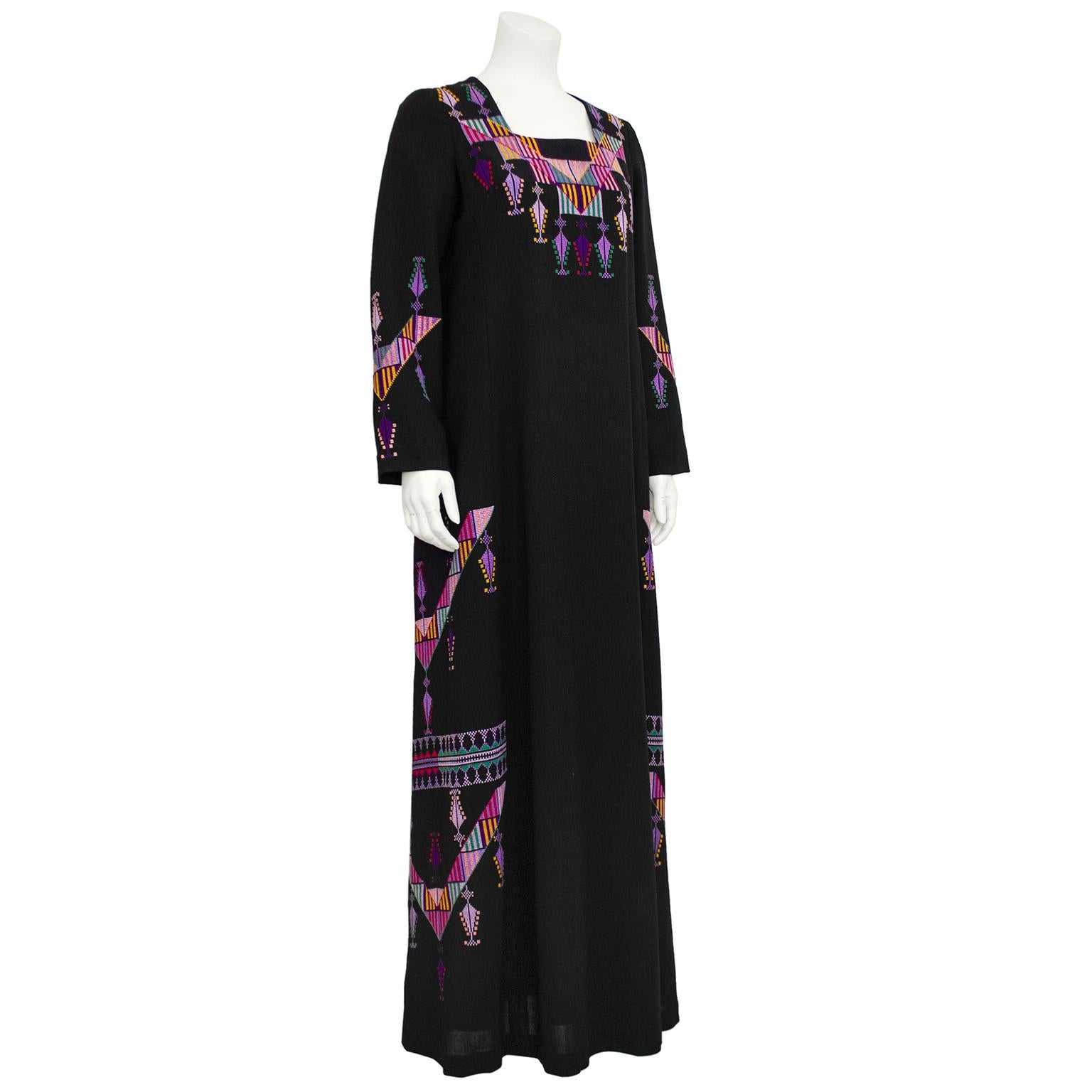 Really stunning made in Israel  kaftan from the 1970s by well known design house Maskit. Fine black wool with long sleeves and a square neckline. The kaftan is embellished with beautifully eye catching multi colour cross stitch embroidery at the