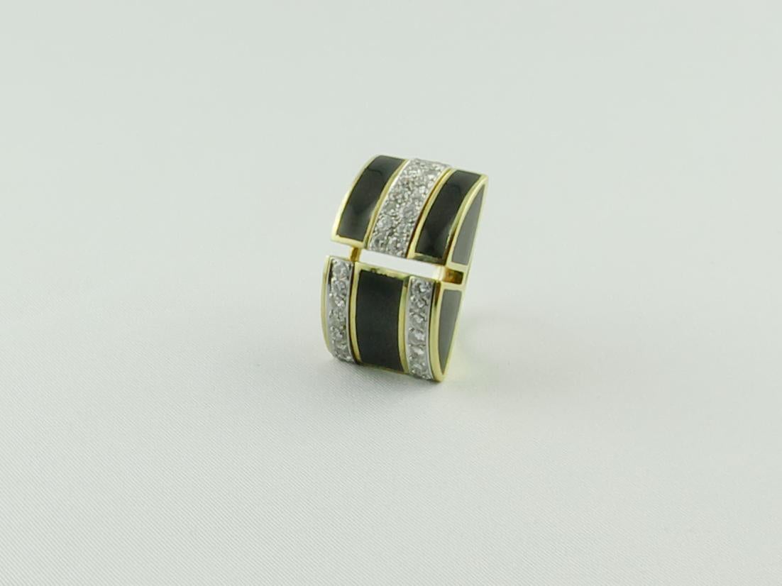 An imposing 1970s Cocktail Ring in 18 karat Yellow Gold 
This stunningly chic Ring features smooth black Enamel segmented by 1.20 carats of white round cut Diamonds set in 18K White Gold. 
The striking black Enamel is in good conditions and makes a