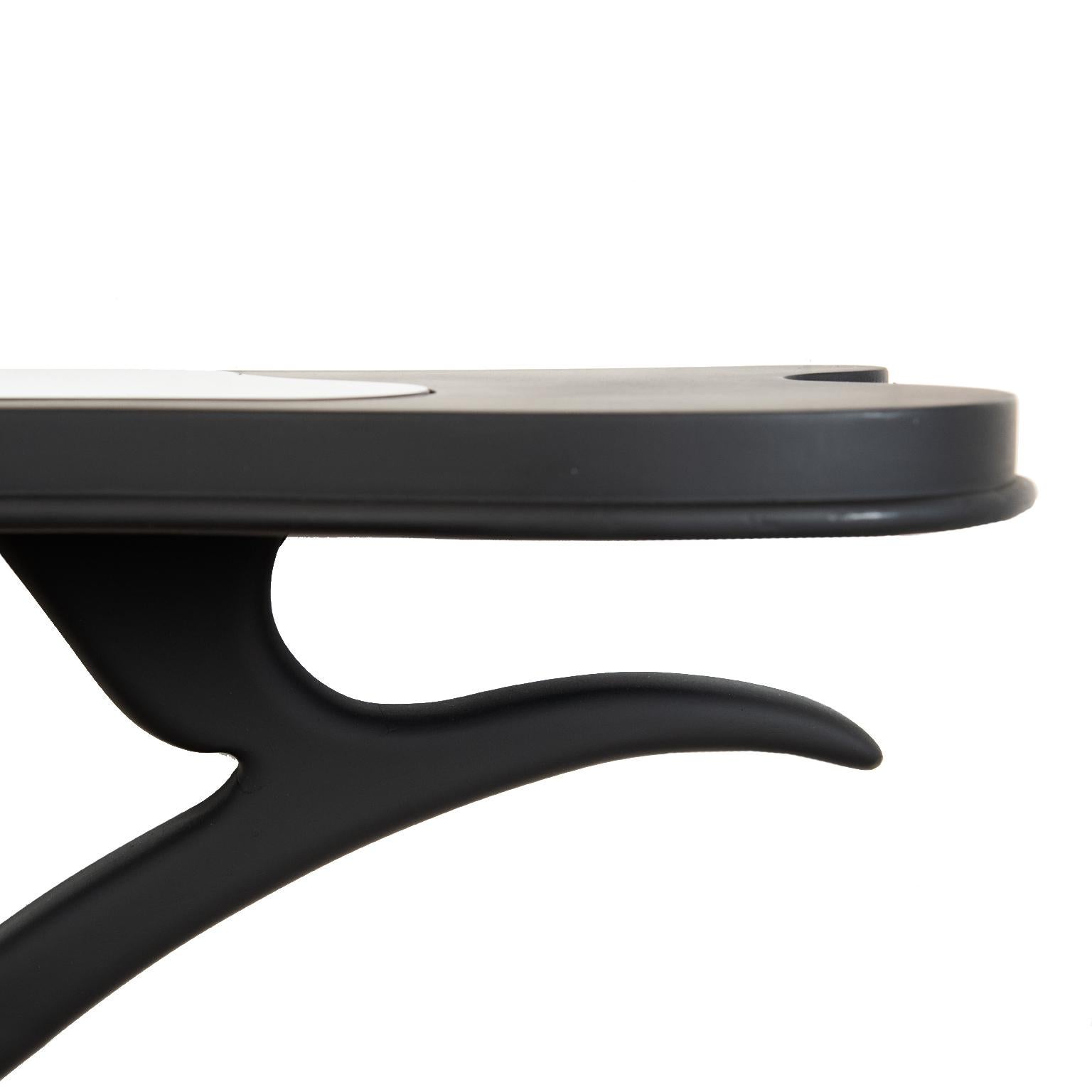 This chic and curvaceous black painted decorator table with a black glass insert is designed to be mounted to the wall with its demilune design.